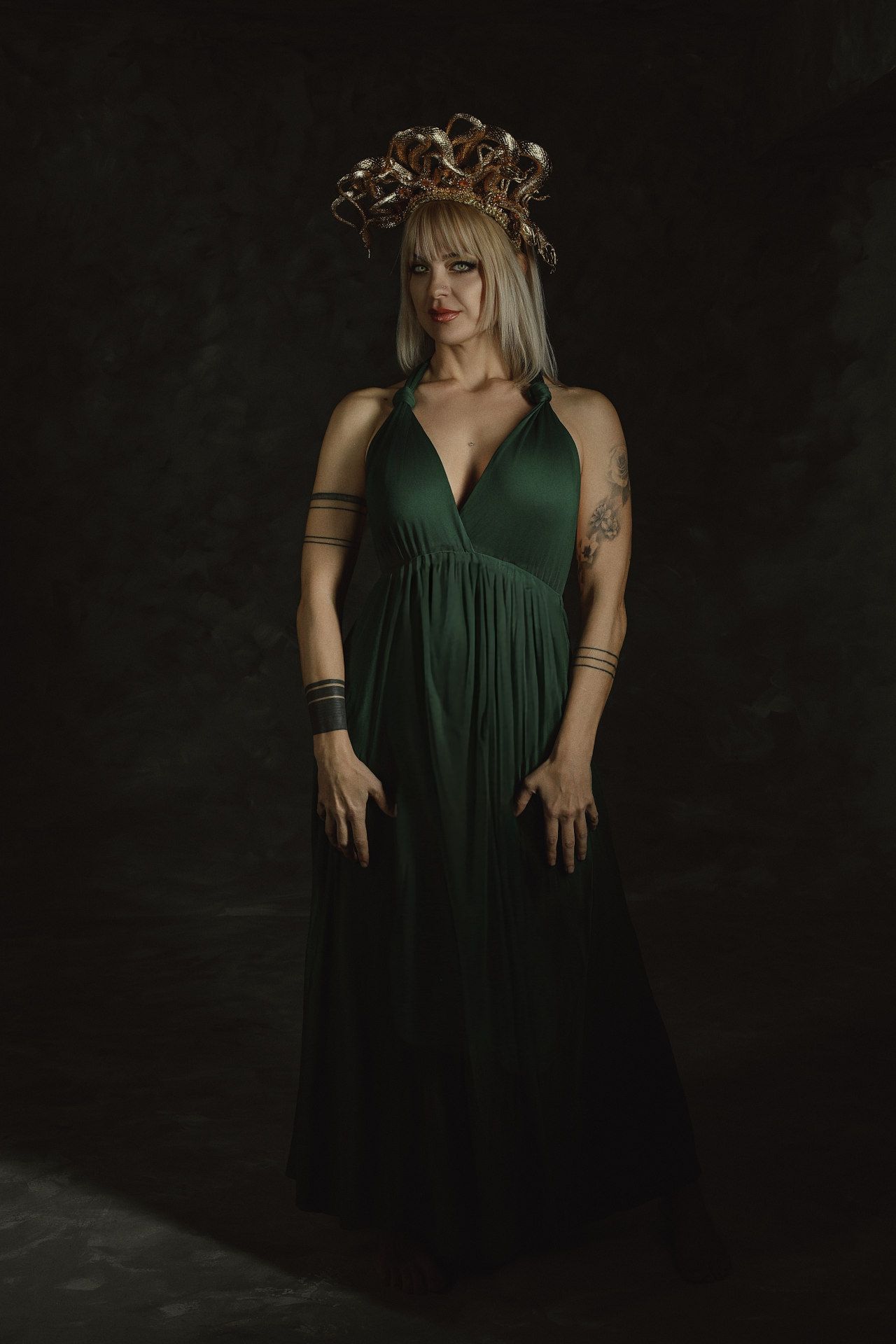 Detailed portrait of a tourist as Medusa wearing a handcrafted crown of snakes in a professional Greek photography studio.