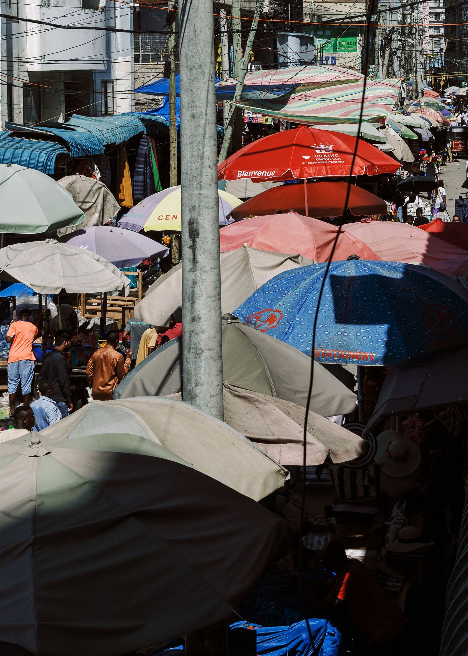 Aerial view print of colorful market umbrellas in Kariakoo, textured documentary photography for modern interior design by Naezi Eyes.