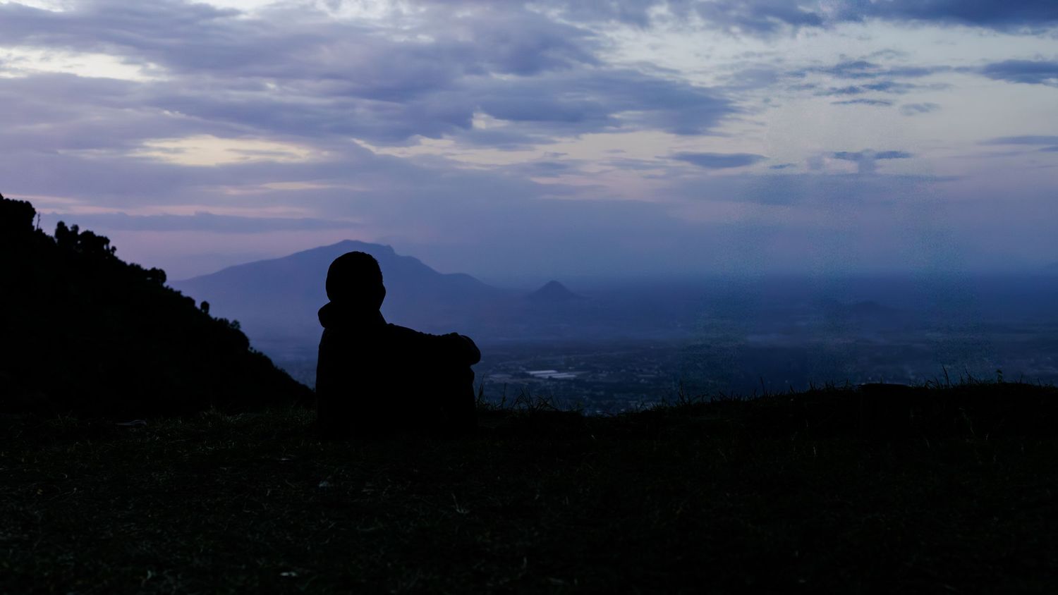 Silhouette of photographer Natalia Msungu overlooking Morogoro landscape in Tanzania, representing the adventurous and contemplative spirit.