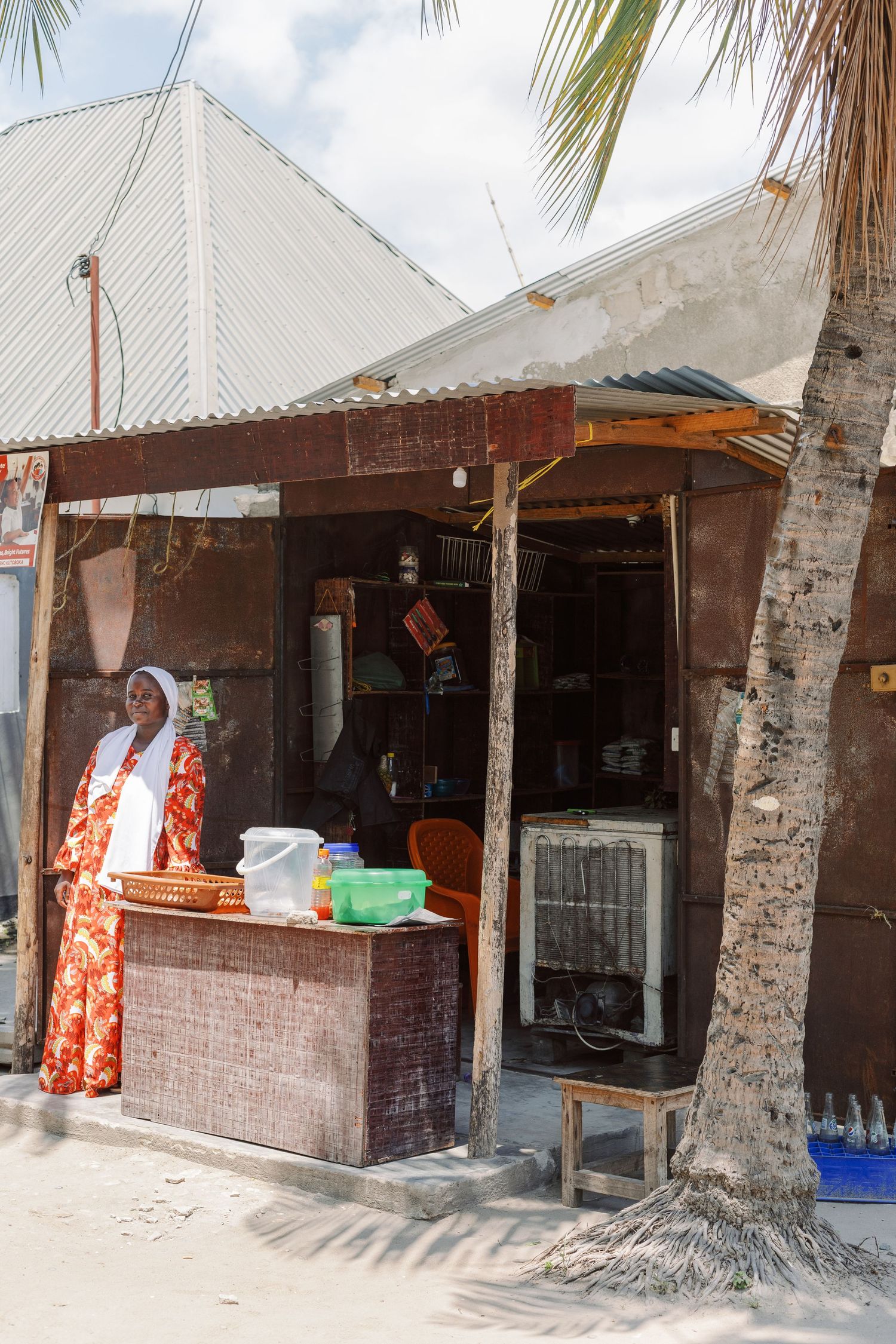 Woman working at her small business stall, dignified NGO storytelling photography for African Road by Naezi Eyes.