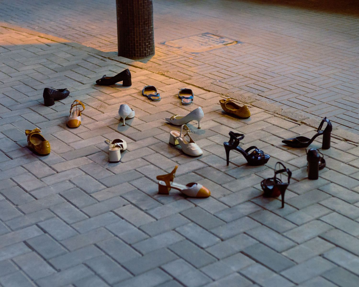 Conceptual fine art print featuring high heels arranged on an urban pavement, artistic narrative photography about presence and absence.