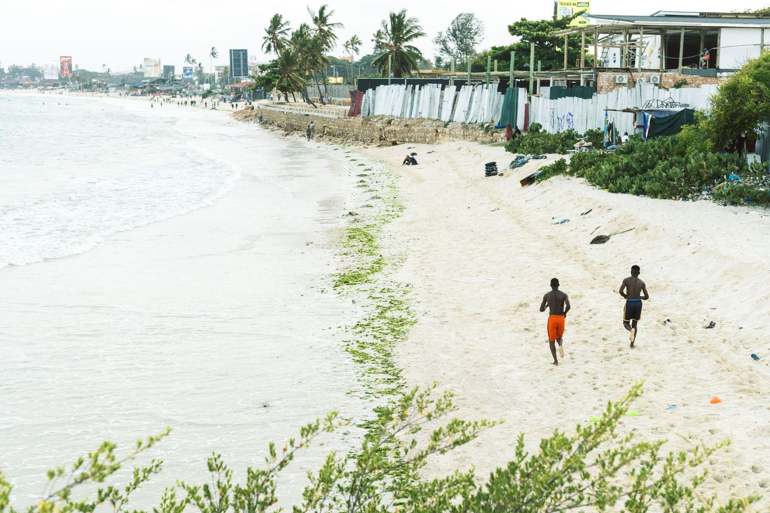 People exercising along the white sandy coastline of Dar es Salaam, documenting the intersection of city and sea.