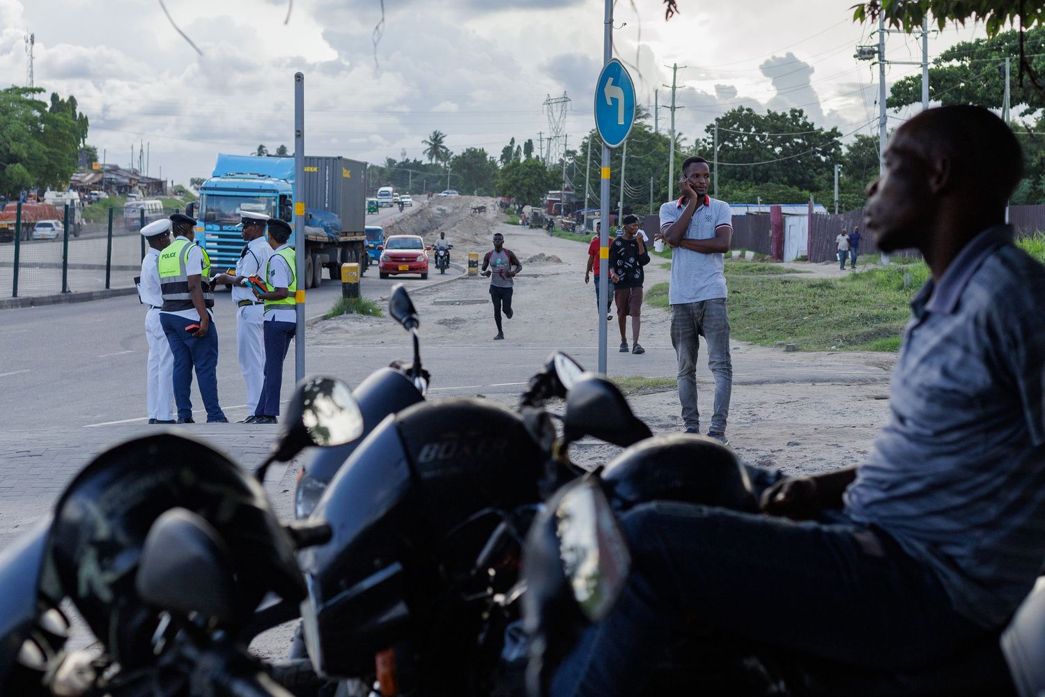 Boda boda motorcycle taxi riders waiting in traffic, authentic urban transport culture and street life in Tanzania by Naezi Eyes.