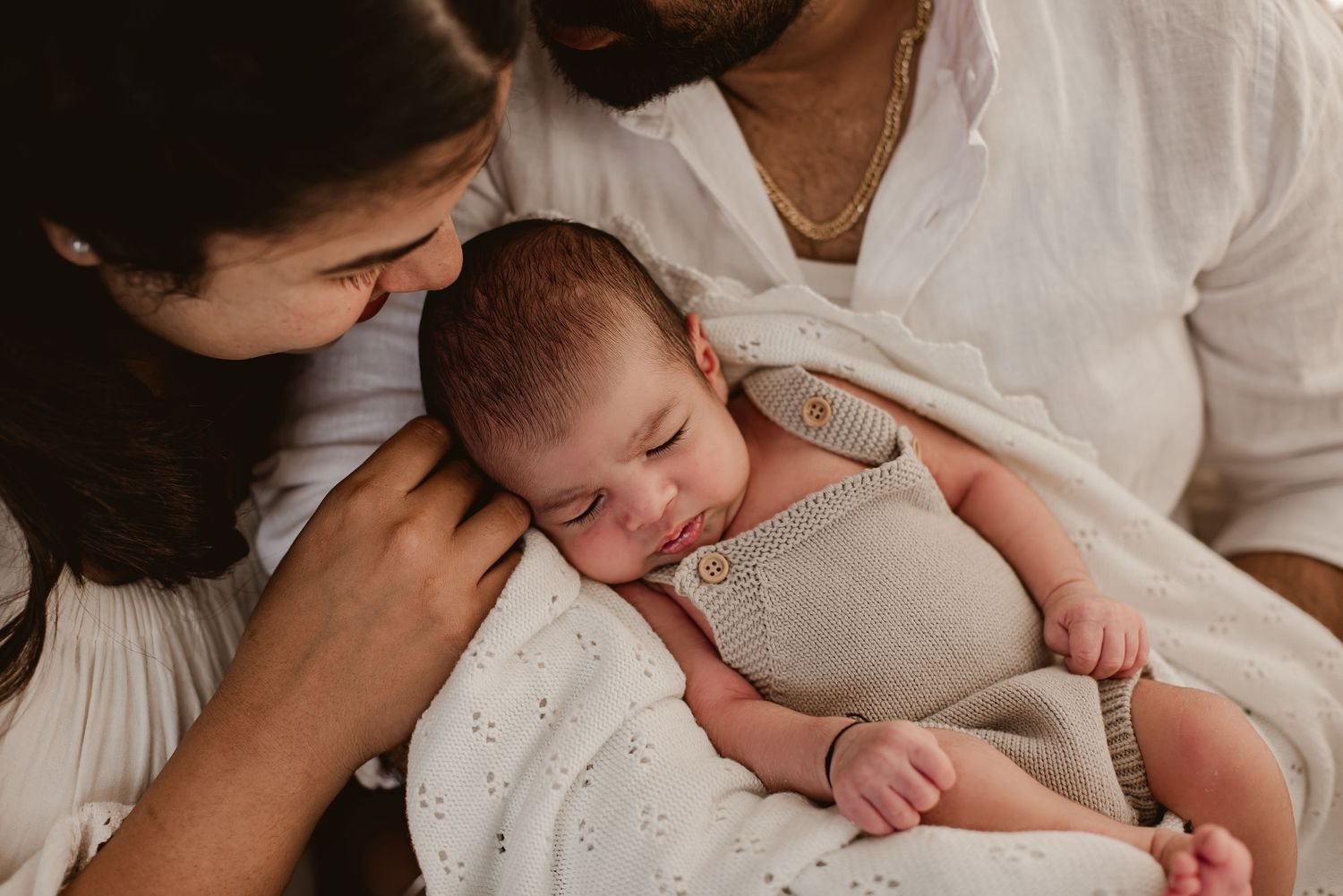 Intimate family portrait with newborn baby in neutral tones.