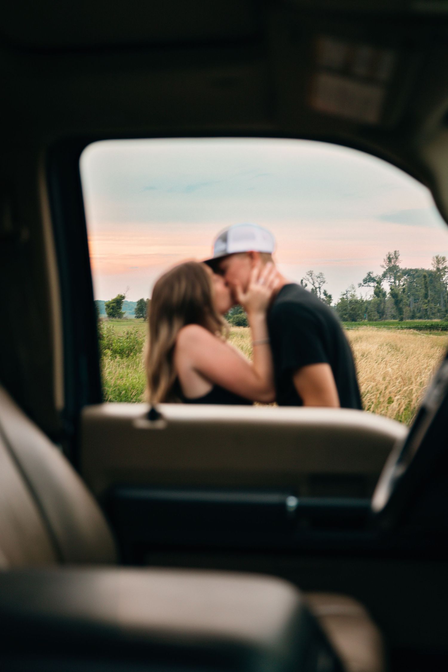 Scenic countryside views framed through car windows at sunset.