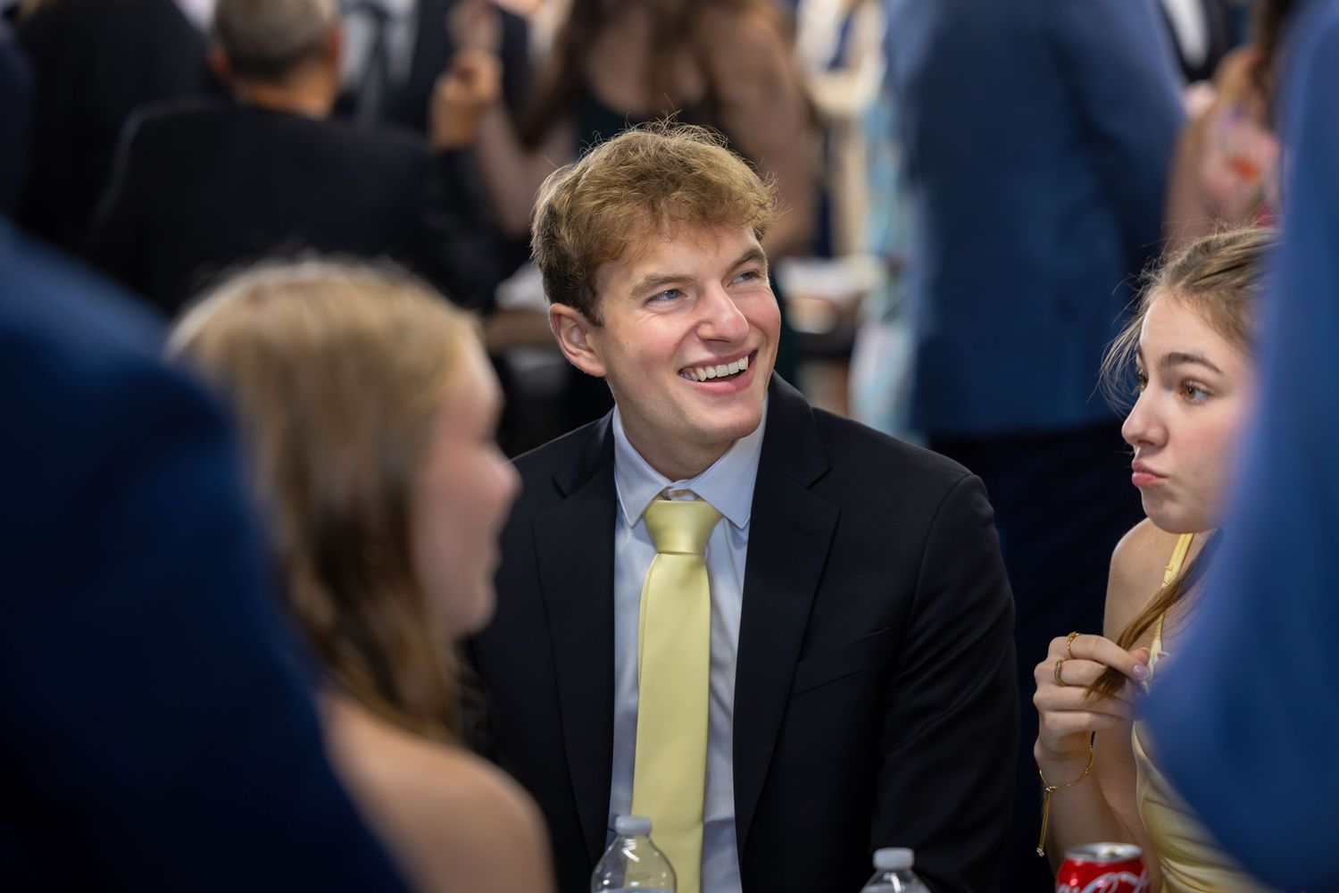 Wedding guests enjoying conversation and drinks during an evening reception.