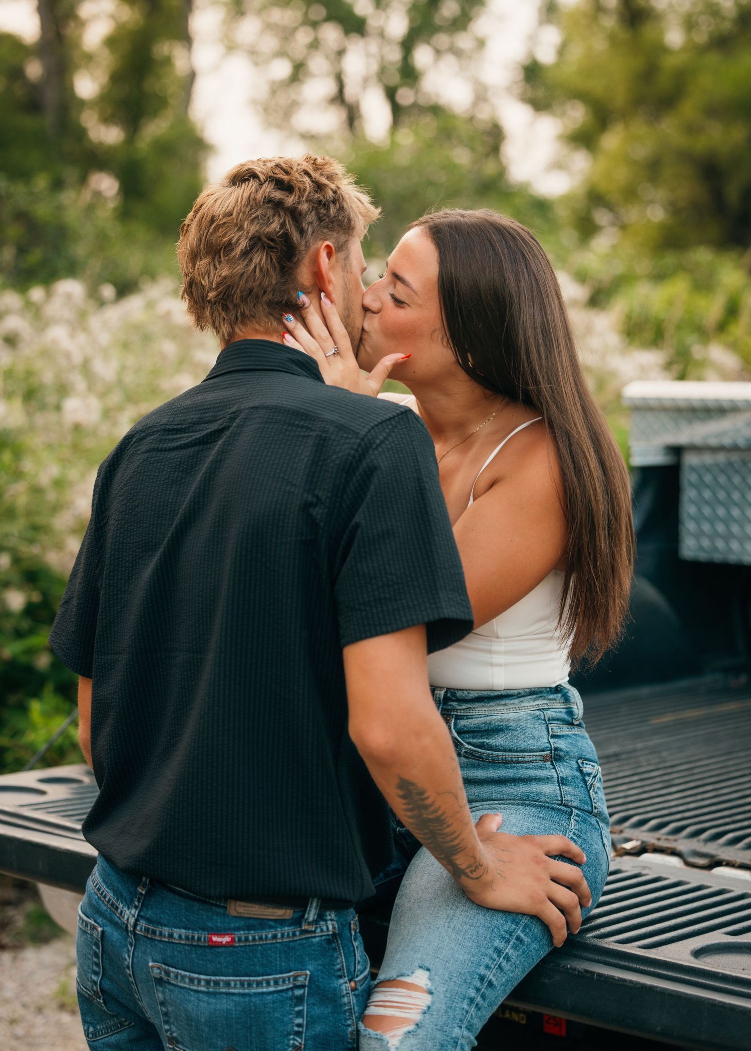 Intimate couple sharing a romantic moment on the back of a pickup truck.