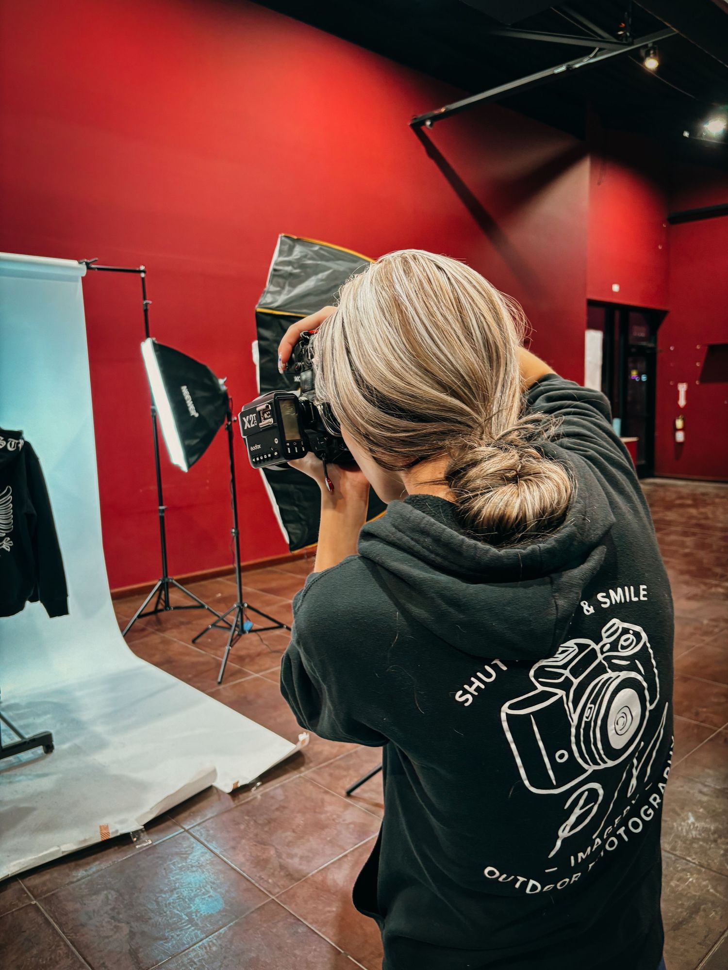 Photography studio setup with red walls and professional lighting equipment.