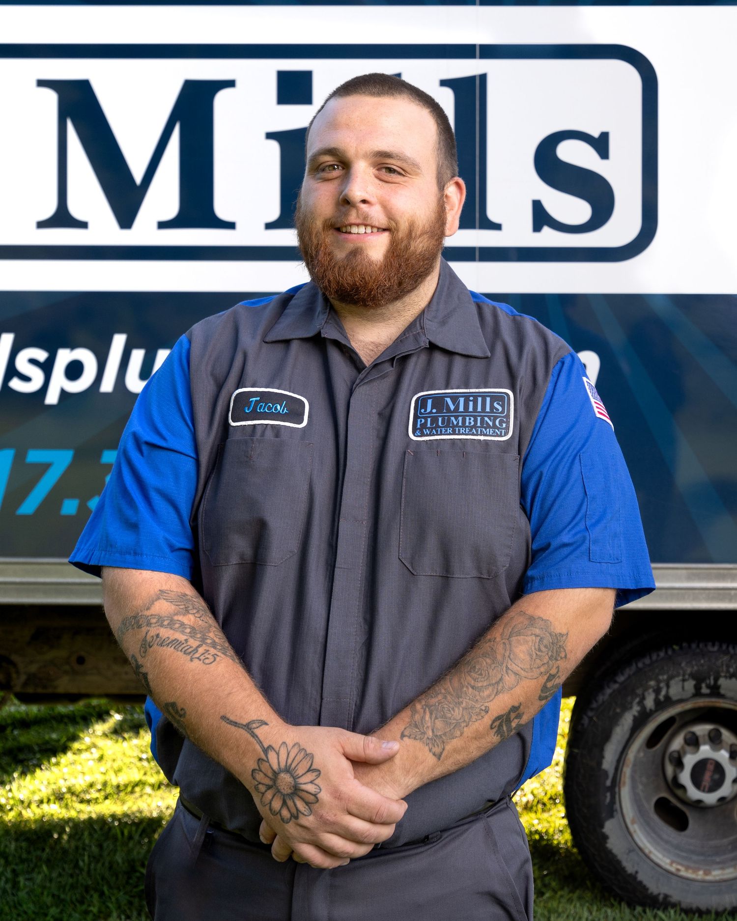 Professional service technician in uniform standing by company vehicle.