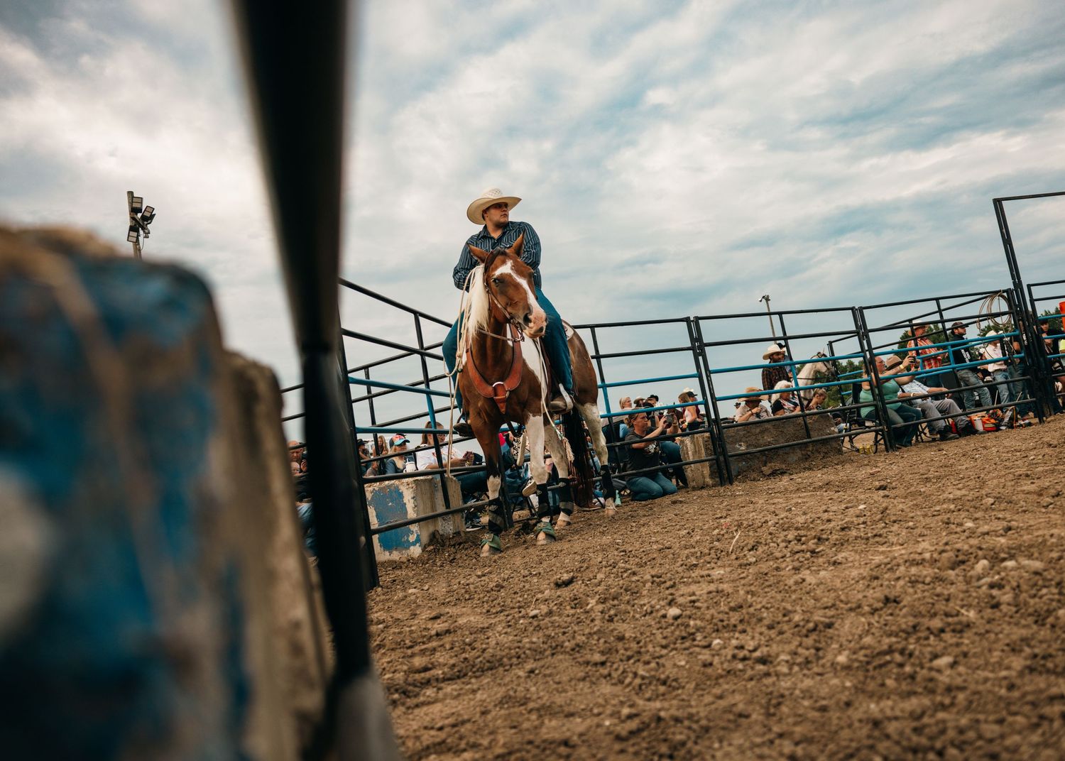 Wide angle view of rodeo arena during competition with spectators.