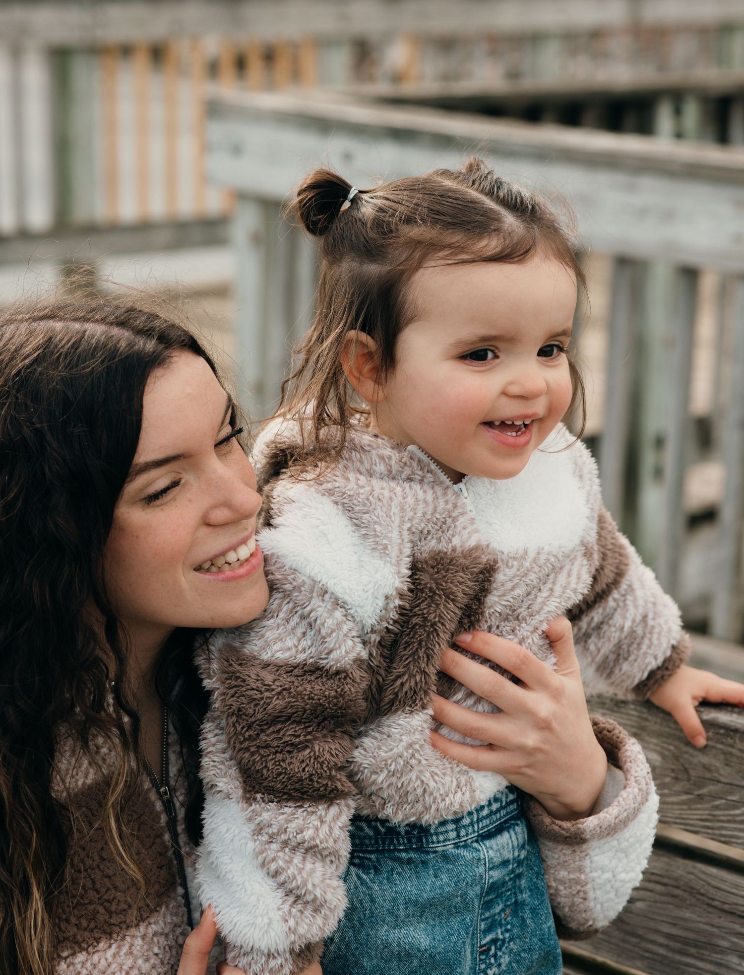A heartwarming moment shared between two people in cozy sweaters on a deck.