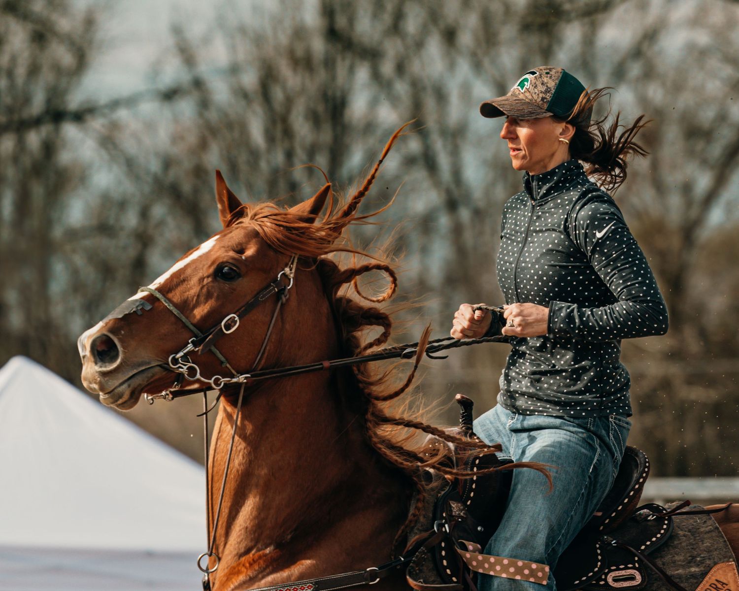 Horse and rider practicing in snowy winter conditions on a training course.
