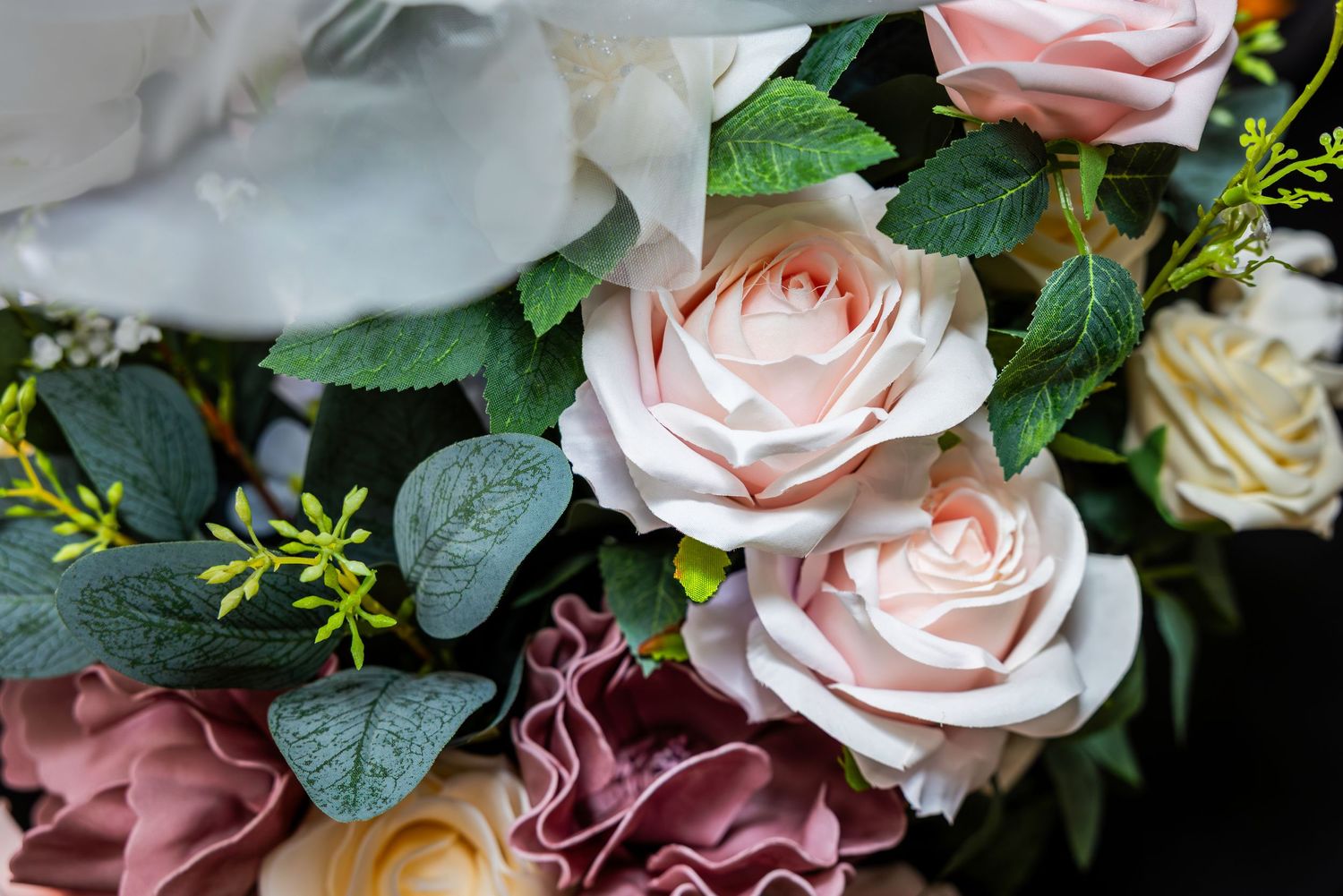 Delicate pink roses and greenery arranged in an elegant floral wedding decoration display.