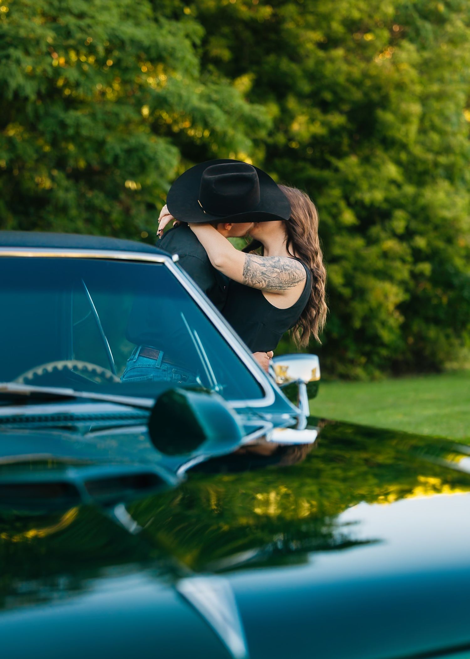 Romantic moment captured through classic car window with reflection.