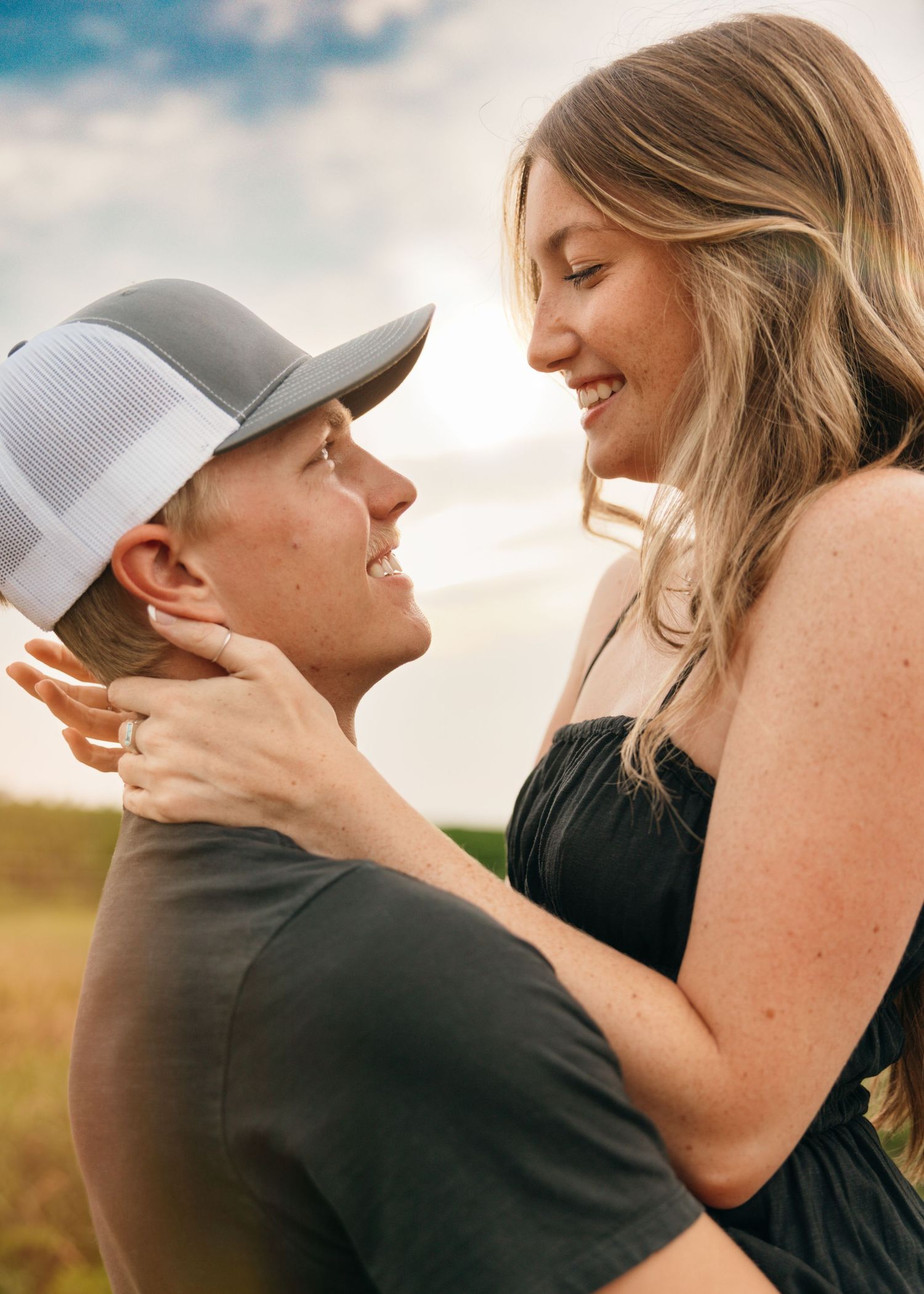 Intimate moment between couple outdoors with soft sunset lighting.
