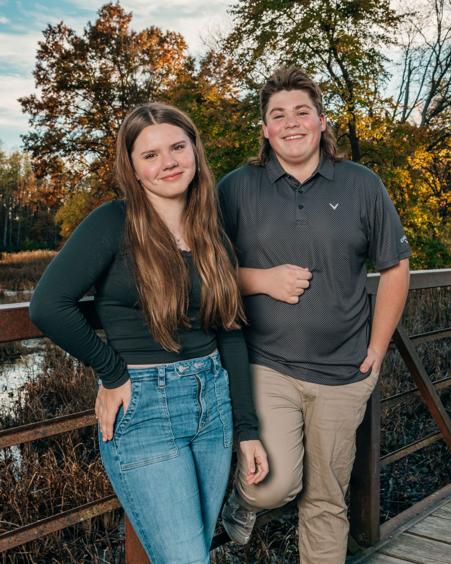 Outdoor autumn family photoshoot with casual attire against fall foliage.