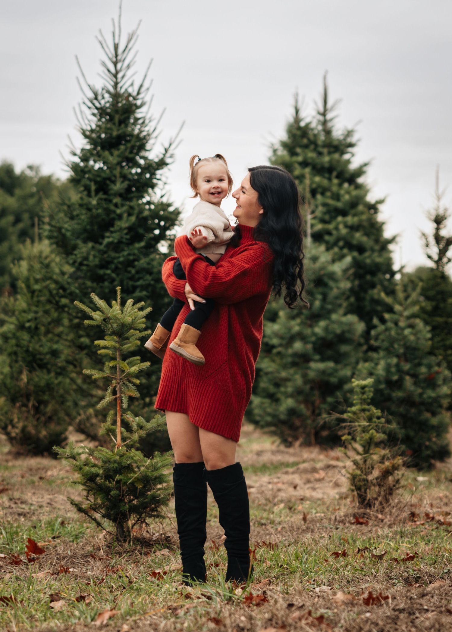 A joyful moment captured among evergreen trees at a Christmas tree farm.