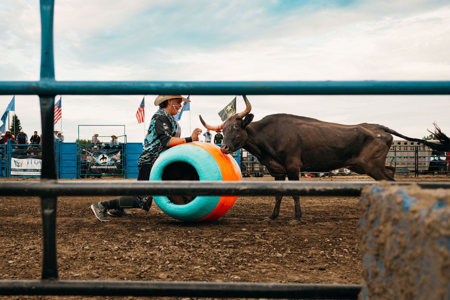 Turquoise rodeo arena gates frame the dusty competition grounds.