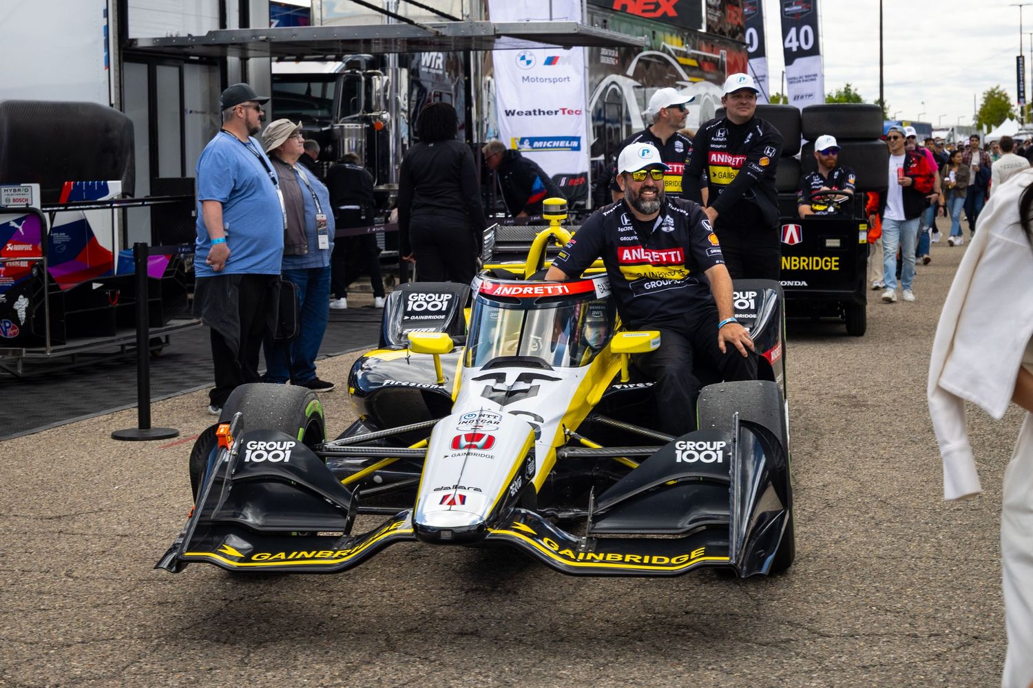 Modern Formula racing cars lined up in pit lane before competition.