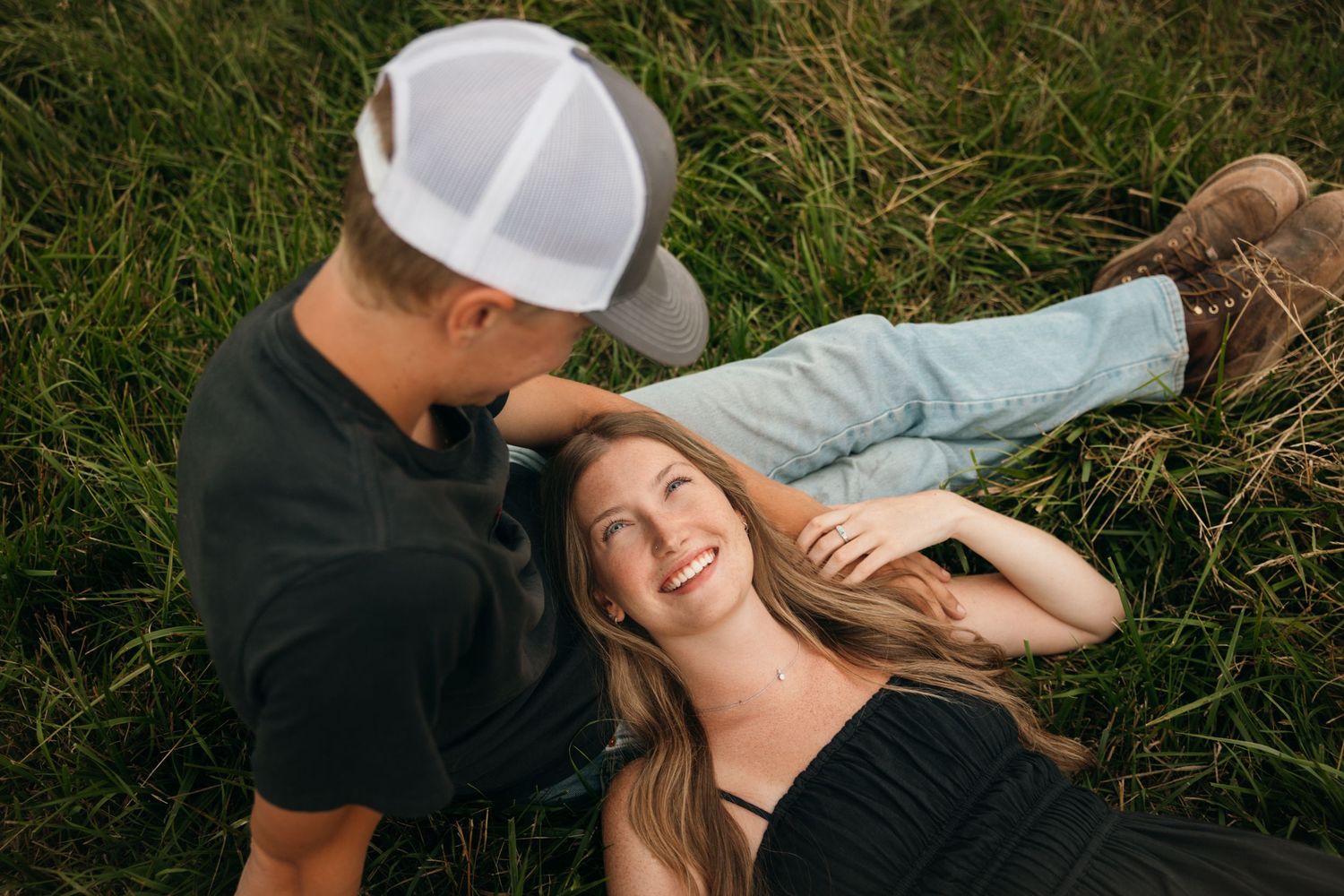 Couple lying in grass sharing a joyful moment together.