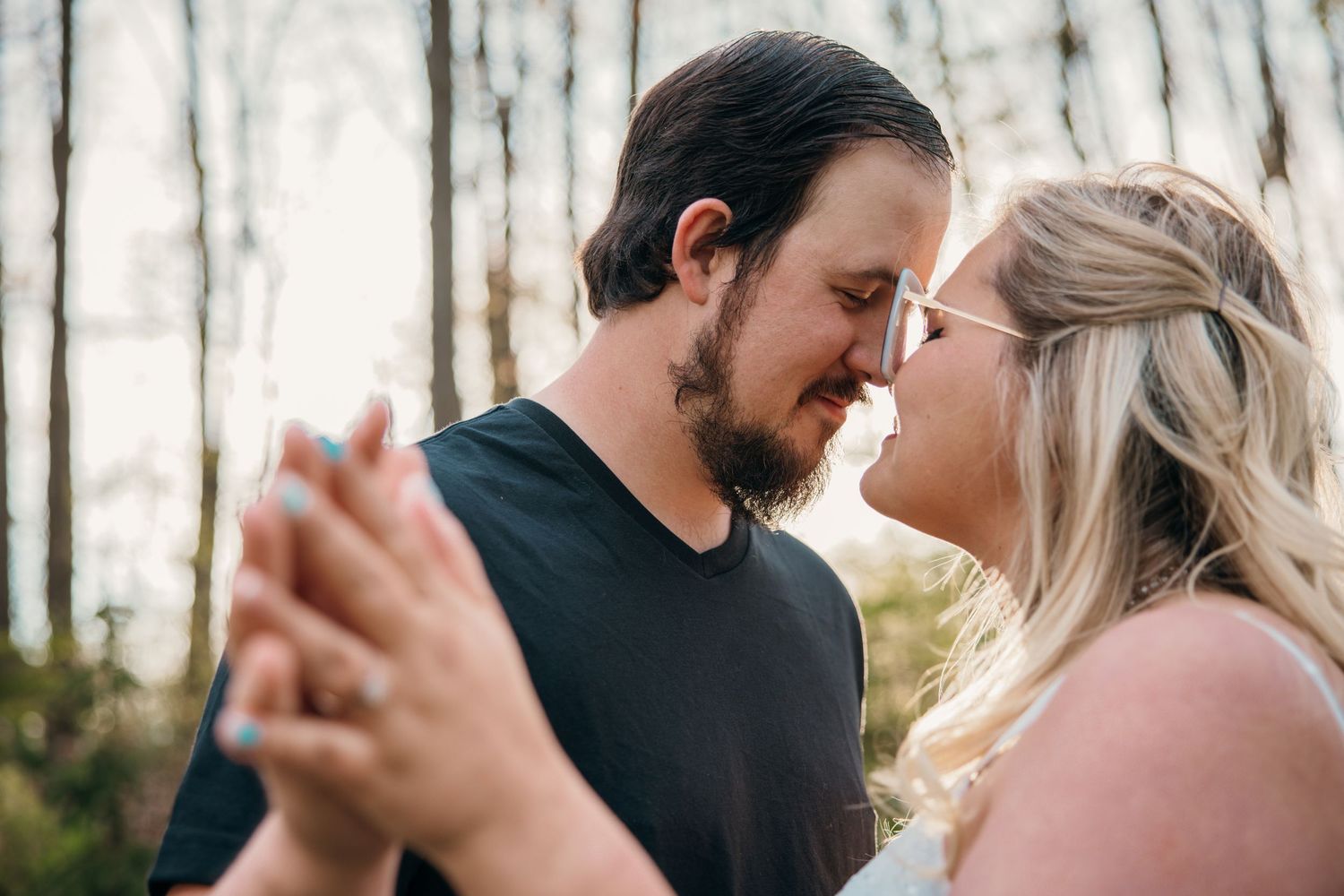 Couple sharing intimate moments in winter forest setting.
