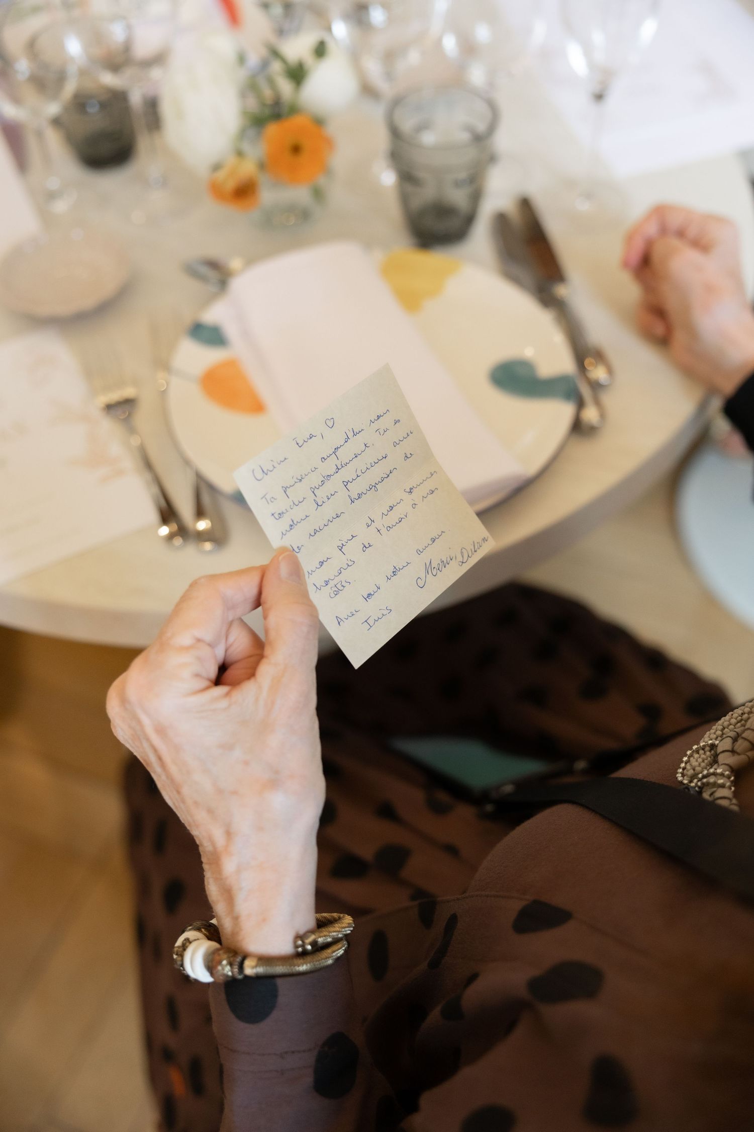 Photographe mariage civil Bruxelles – invitée lisant mot personnalisé à table, instant spontané capturé, reportage mariage naturel Bruxelles