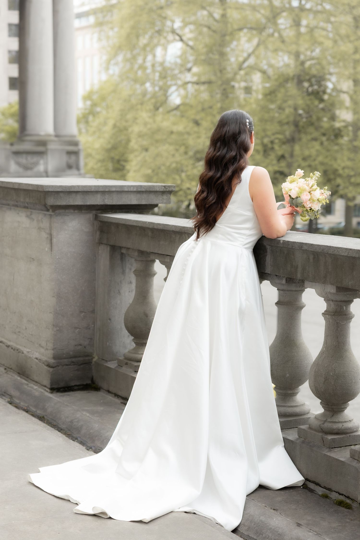 Photo mariage Bruxelles, mariée de dos terrasse, robe longue élégante, portrait mariage artistique et intemporel