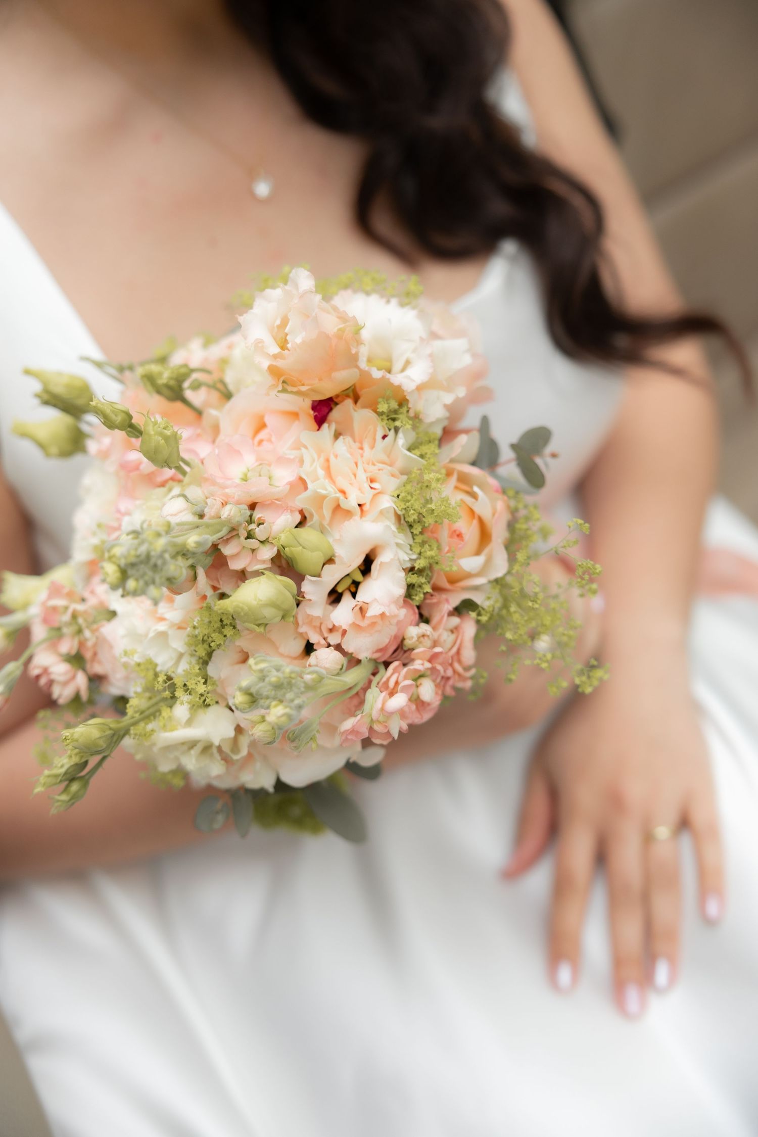 Bouquet de mariée en gros plan tenu à la main, photo mariage élégante Belgique, détails floraux romantiques, lumière douce et esthétique