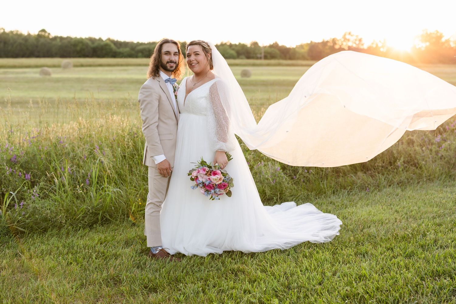 Wedding photography session in field during golden hour with flowing white dress.