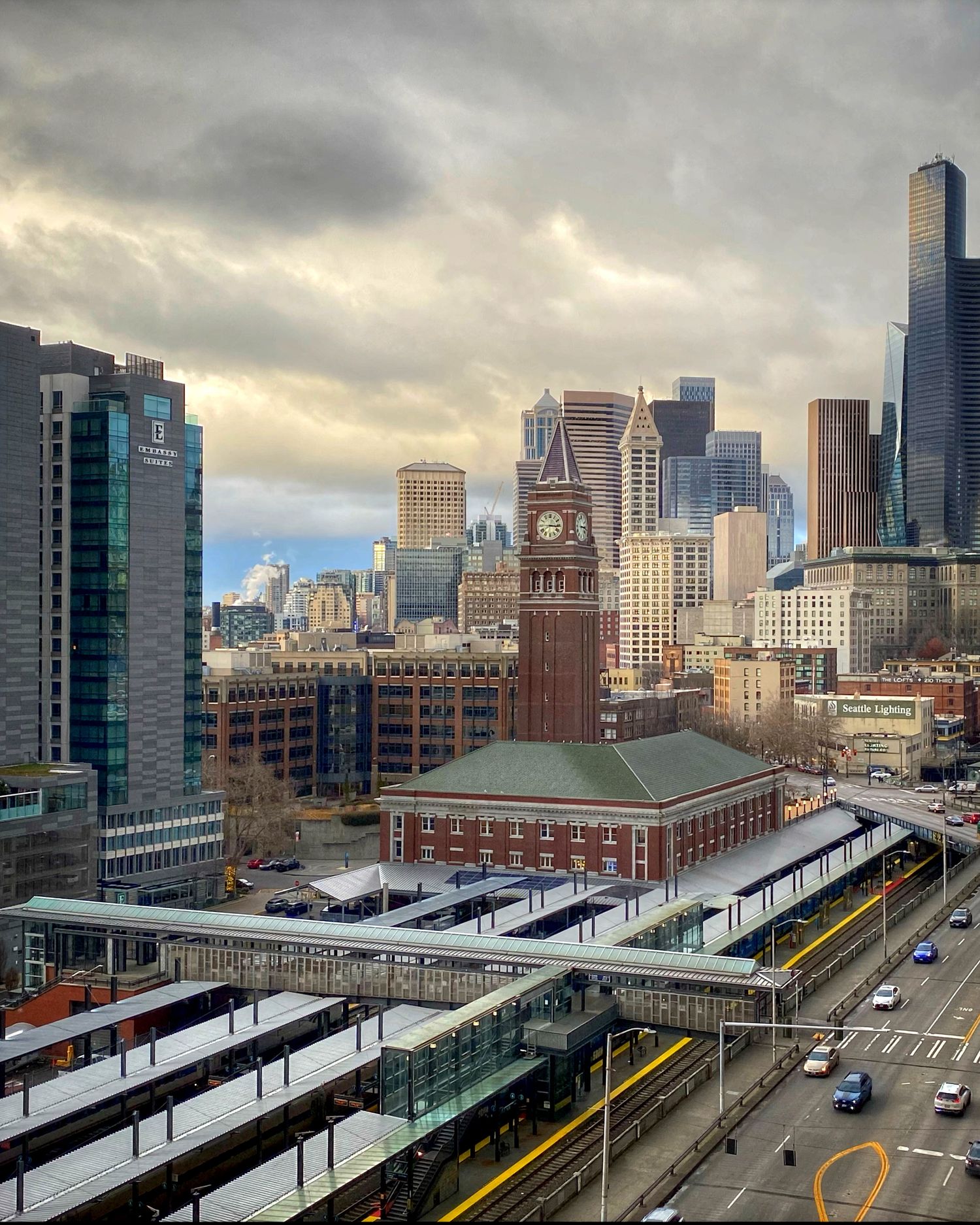 Panoramic cityscape view of Boston with train tracks and modern buildings under cloudy skies.