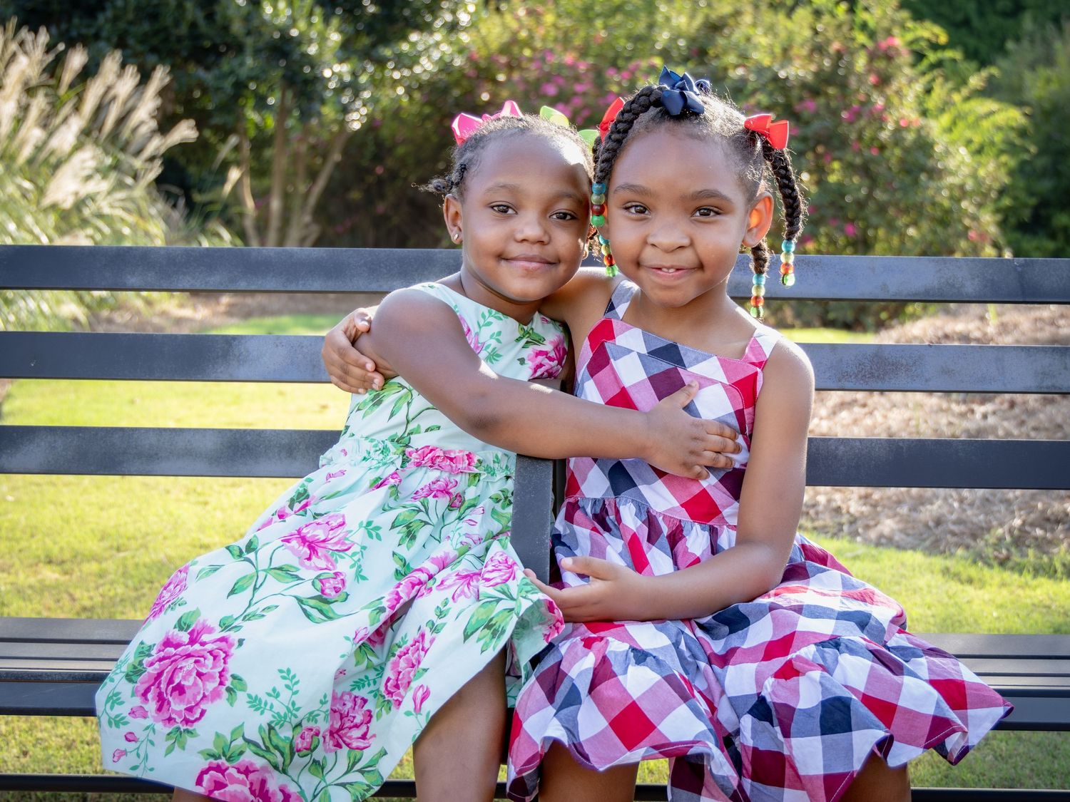 Cheerful summer portrait session with floral and gingham dresses in a park setting.