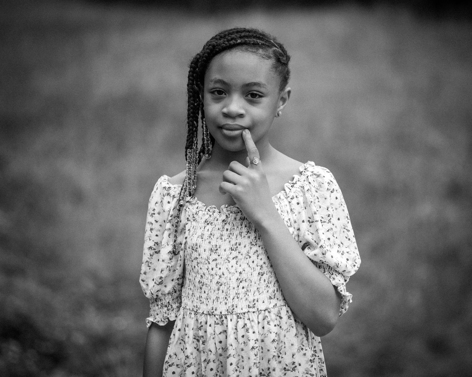 Black and white portrait series showing expressive poses in a floral dress.