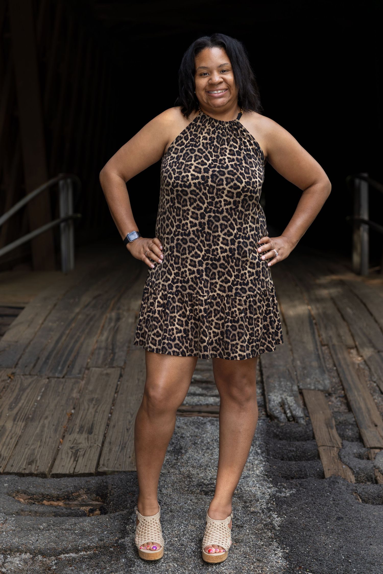 Woman in leopard print dress poses on wooden deck in multiple styled shots.