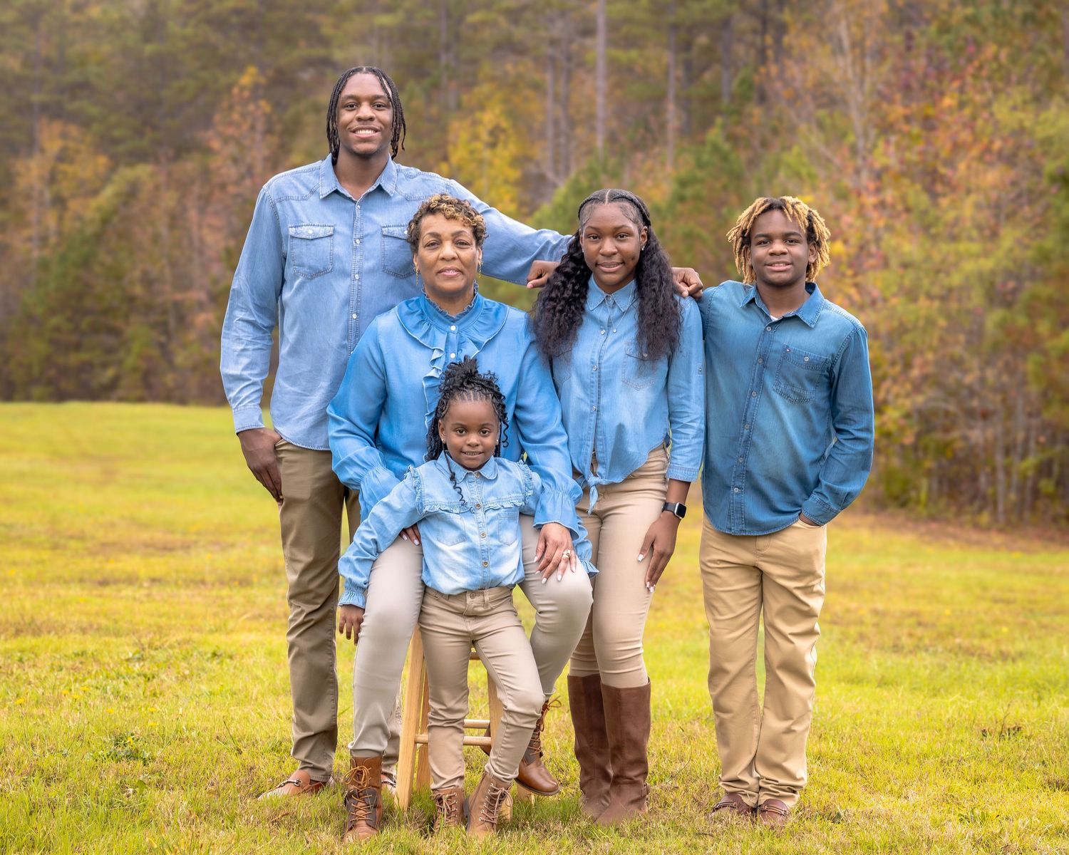 Group portrait with coordinated outfits in a golden autumn field.