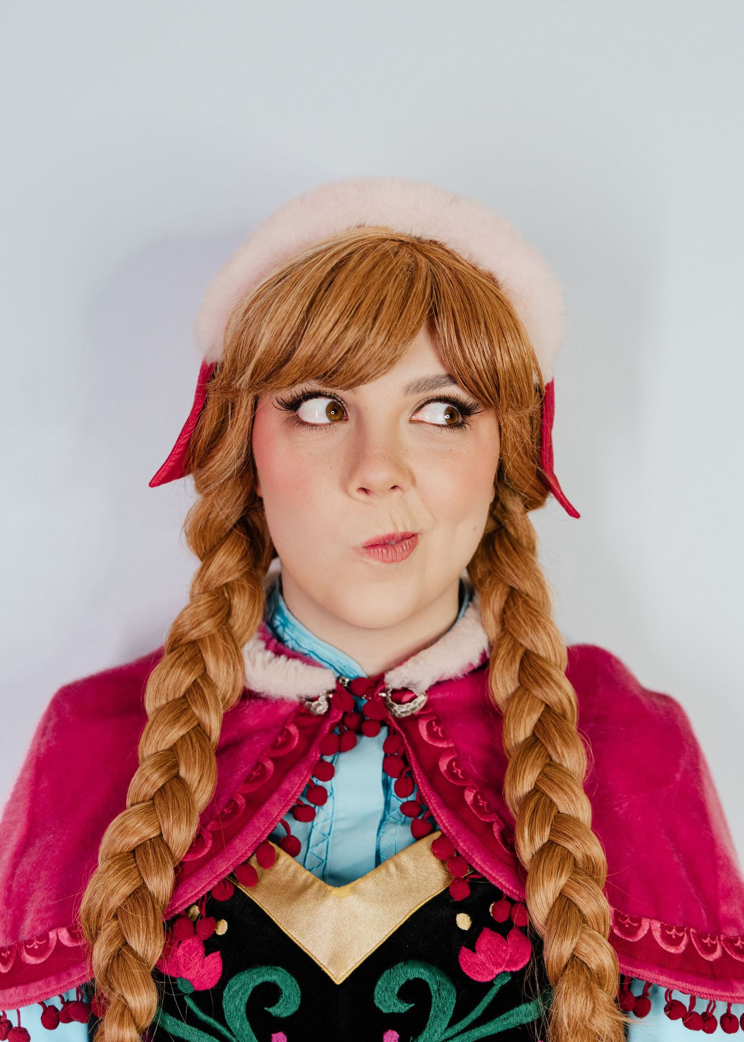 Expressive cosplay portraits showing detailed costume and braided hairstyle.