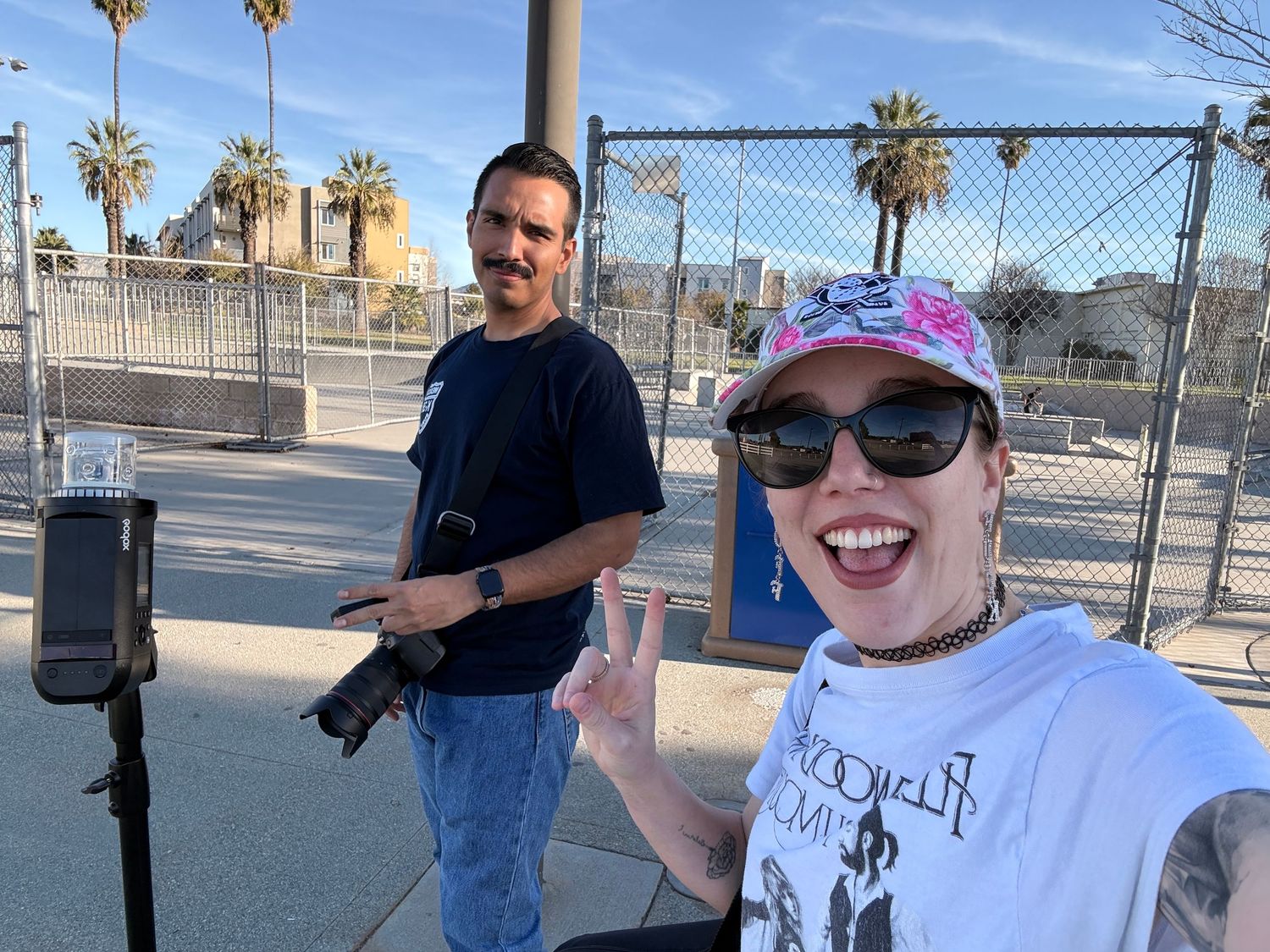 A man and woman displaying peace signs with their hands while smiling at the camera. They are the owners of R.A. Productions.