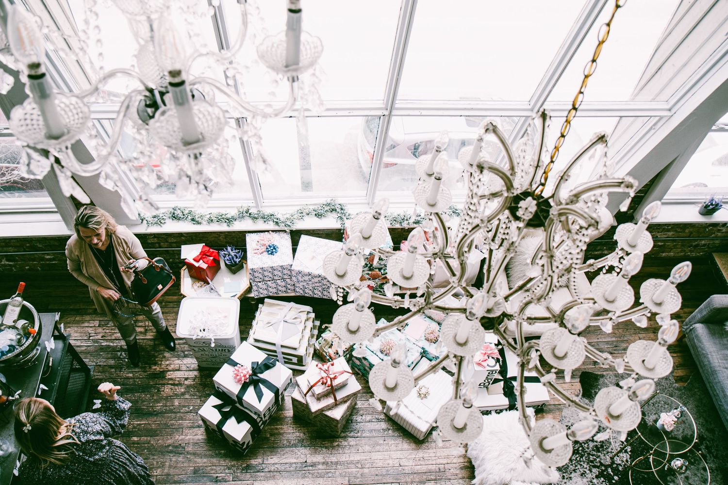 Aerial view of a bright greenhouse space with chandeliers and guests at a bridal shower event.