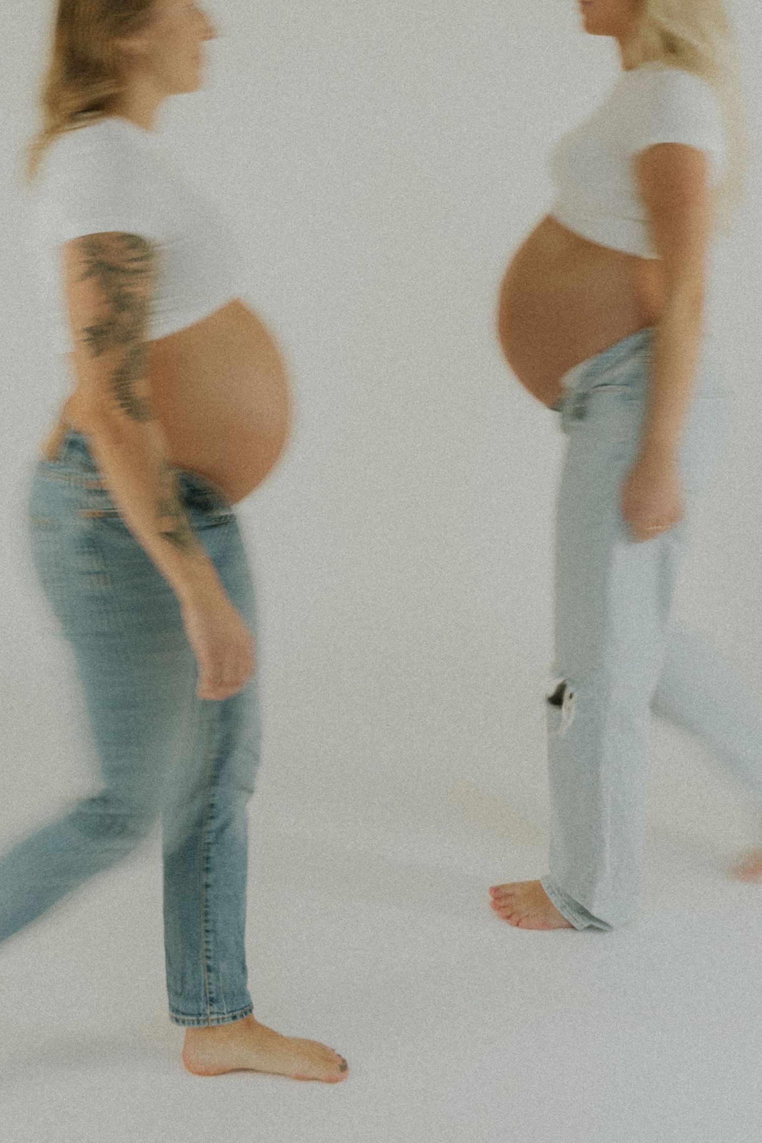 A series of blurred motion photos showing a person in jeans and white top moving against a light background.