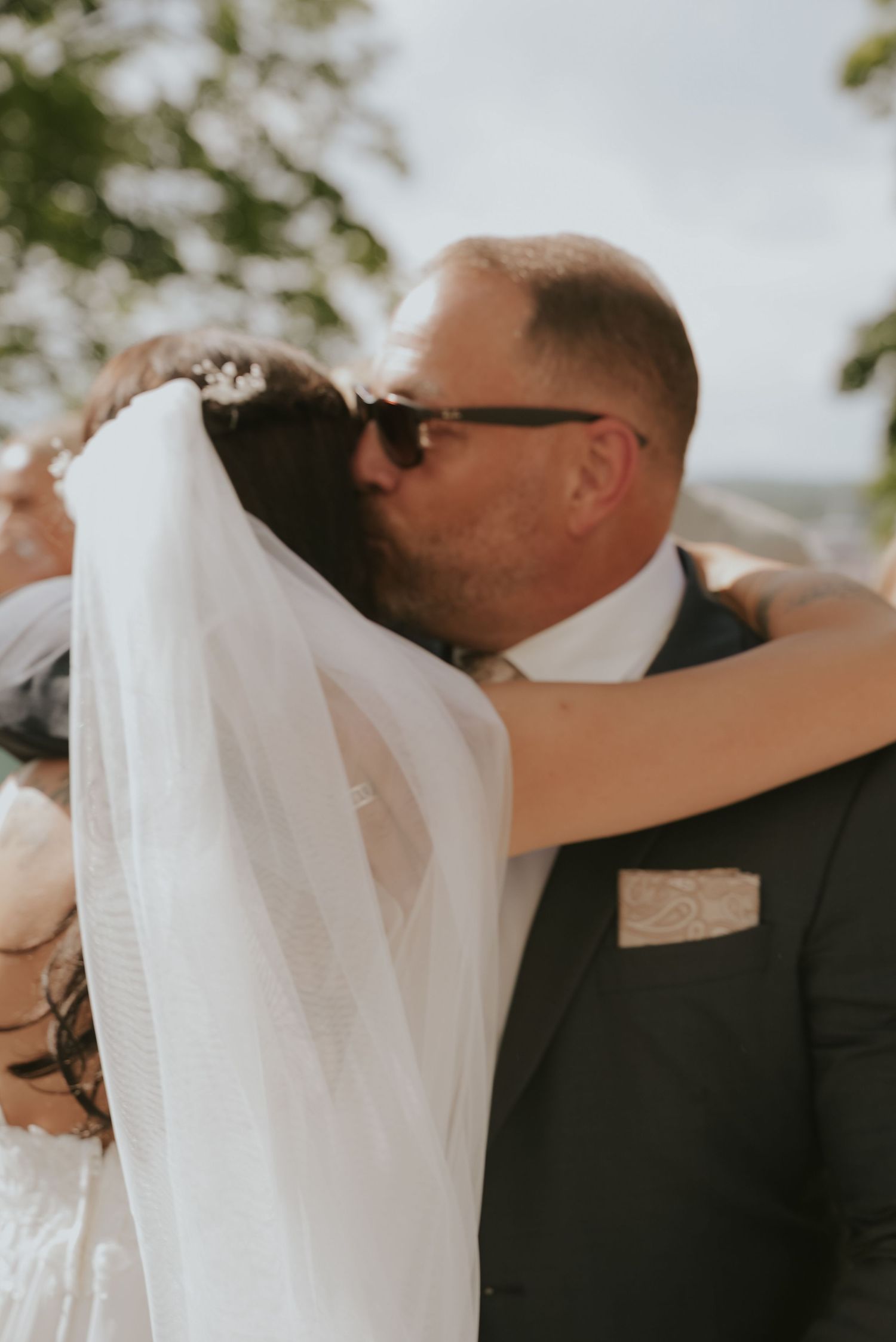 A romantic wedding sequence showing a couple embracing in warm sunlight during their outdoor ceremony.