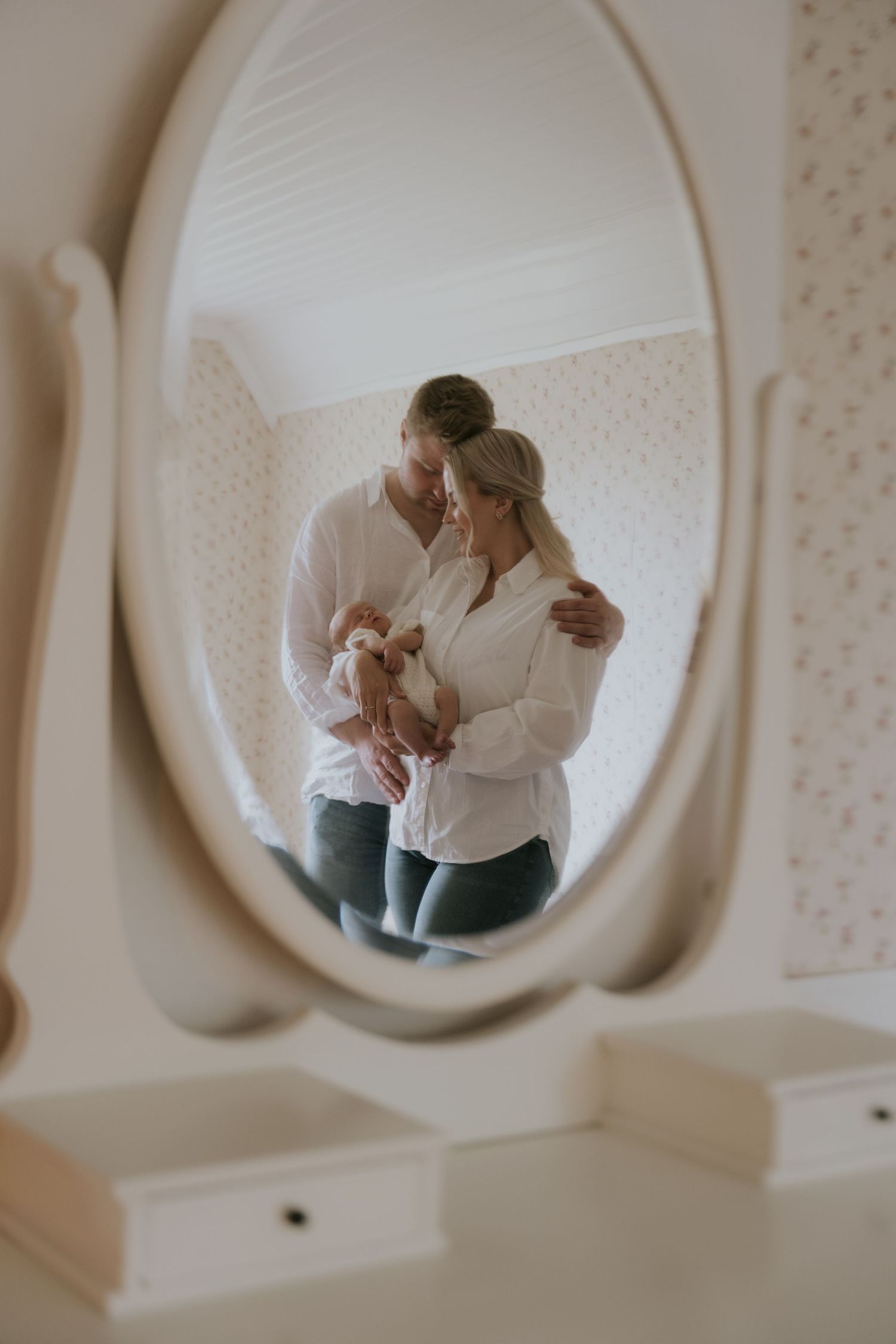 A series of five romantic mirror reflections showing a couple embracing in soft, dreamy lighting against a white wall.