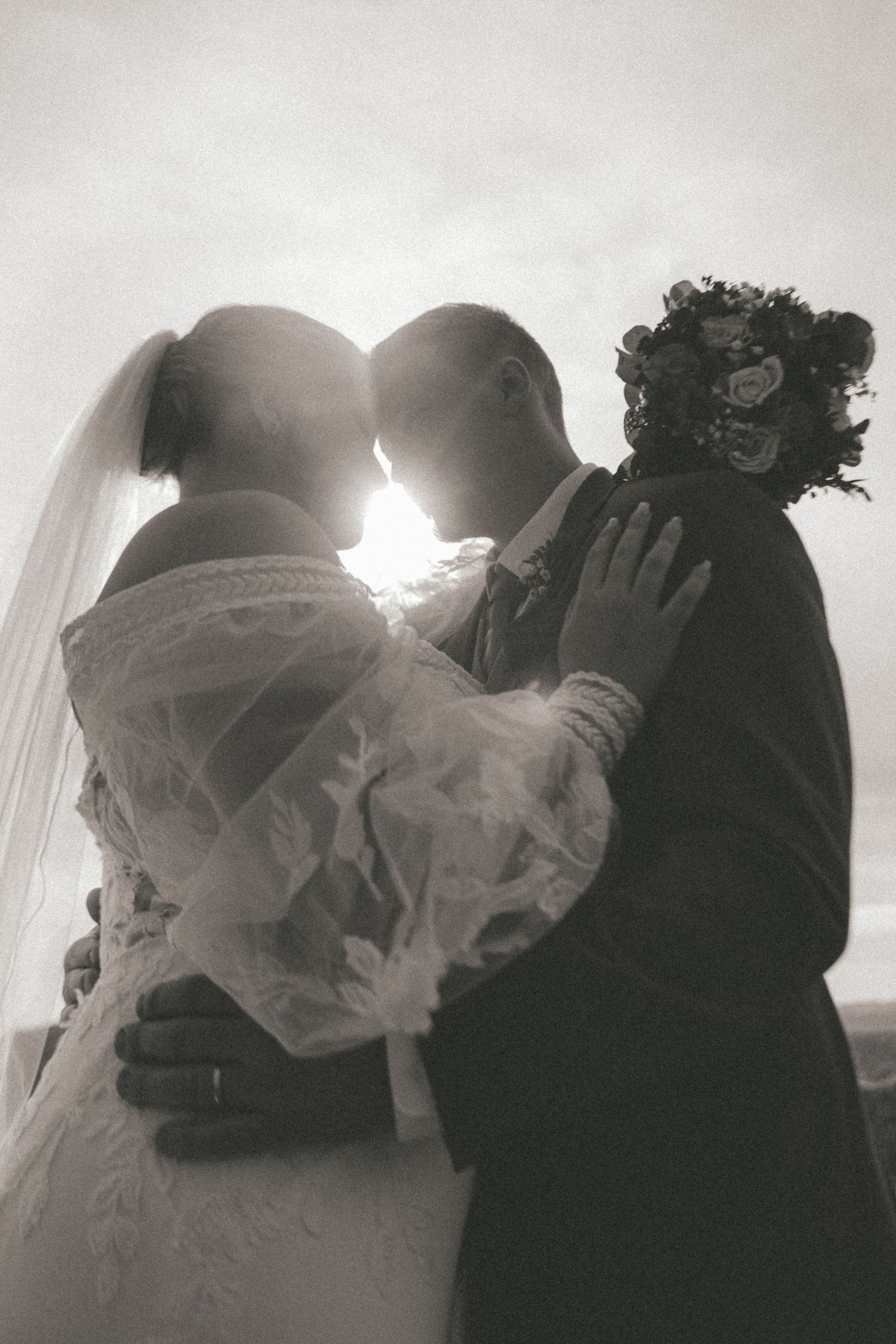 Silhouetted wedding couple shares intimate moments in dramatic black and white photography series.