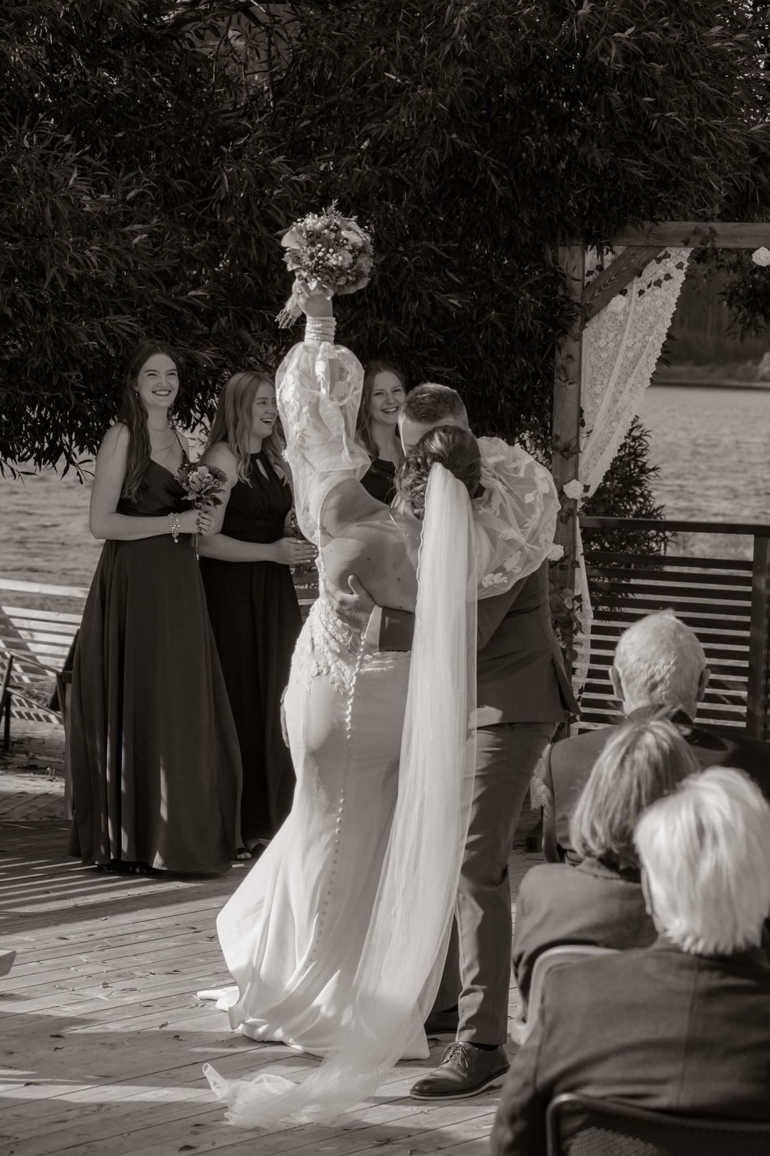 Wedding ceremony in black and white with guests watching the couple exchange vows.