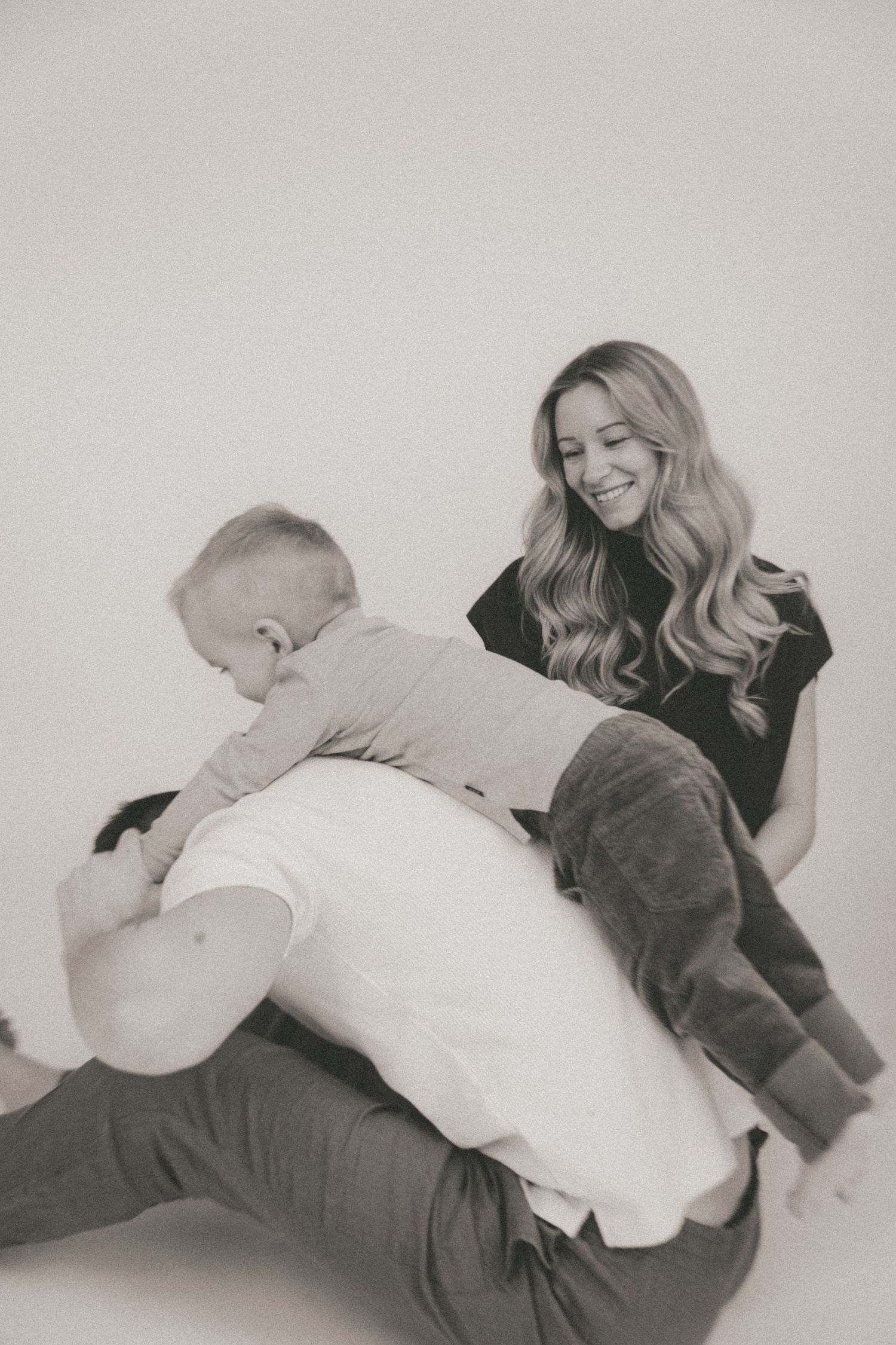 Black and white photo series showing a couple playfully interacting while lying down together.