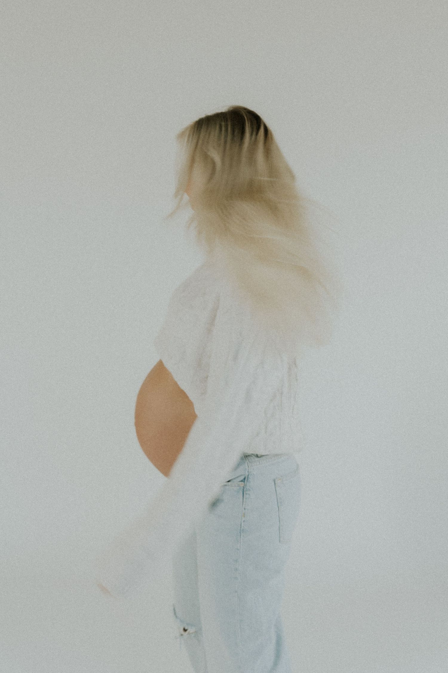 Ethereal maternity portraits with movement showing flowing hair and light clothing.