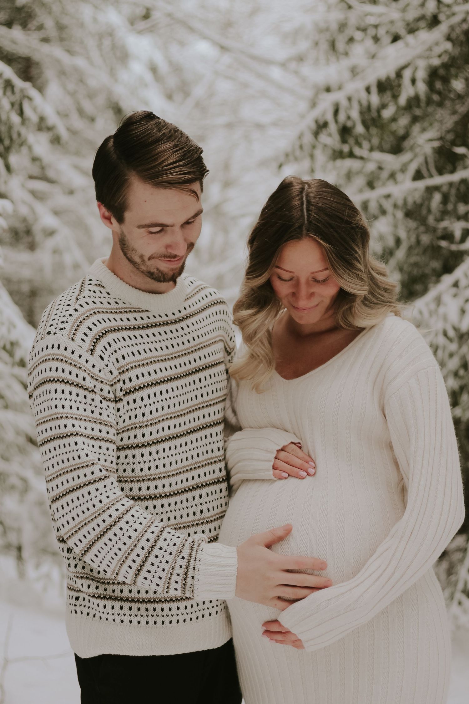 Intimate winter maternity photo session with couple in cozy sweaters.