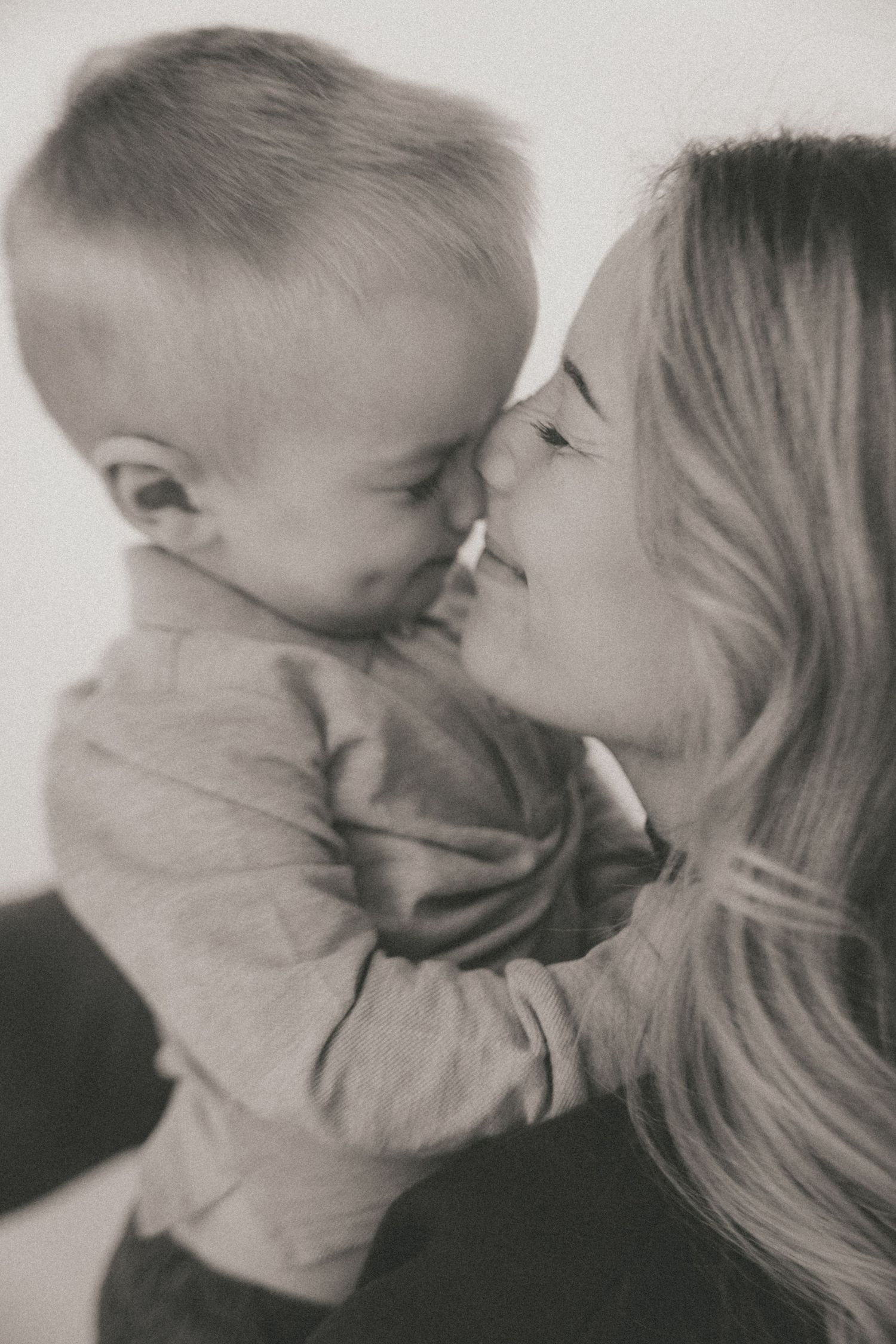 A series of intimate black and white close-up photographs showing gentle affection between loved ones.