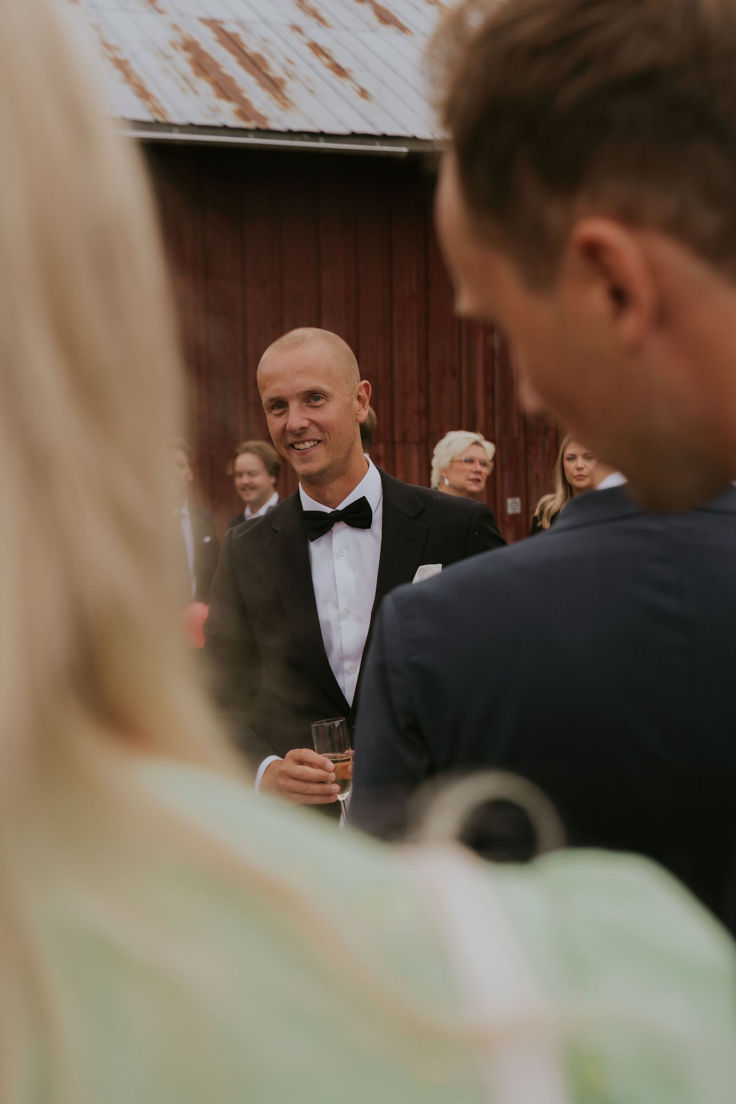 Wedding guests in formal attire gather and socialize during an elegant reception event.