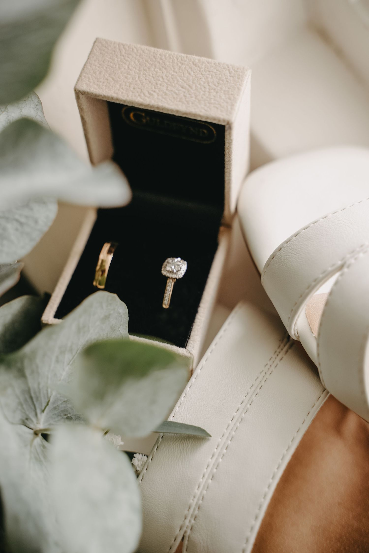Wedding jewelry boxes arranged artistically with soft white floral accents.