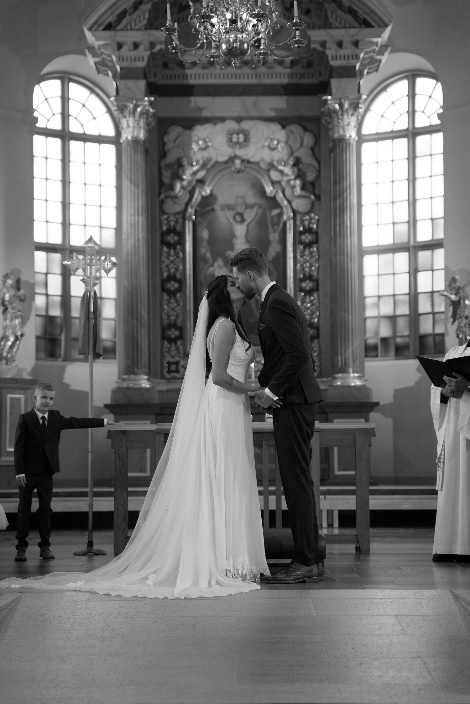 A black and white wedding ceremony sequence showing a couple exchanging vows in an elegant church interior.