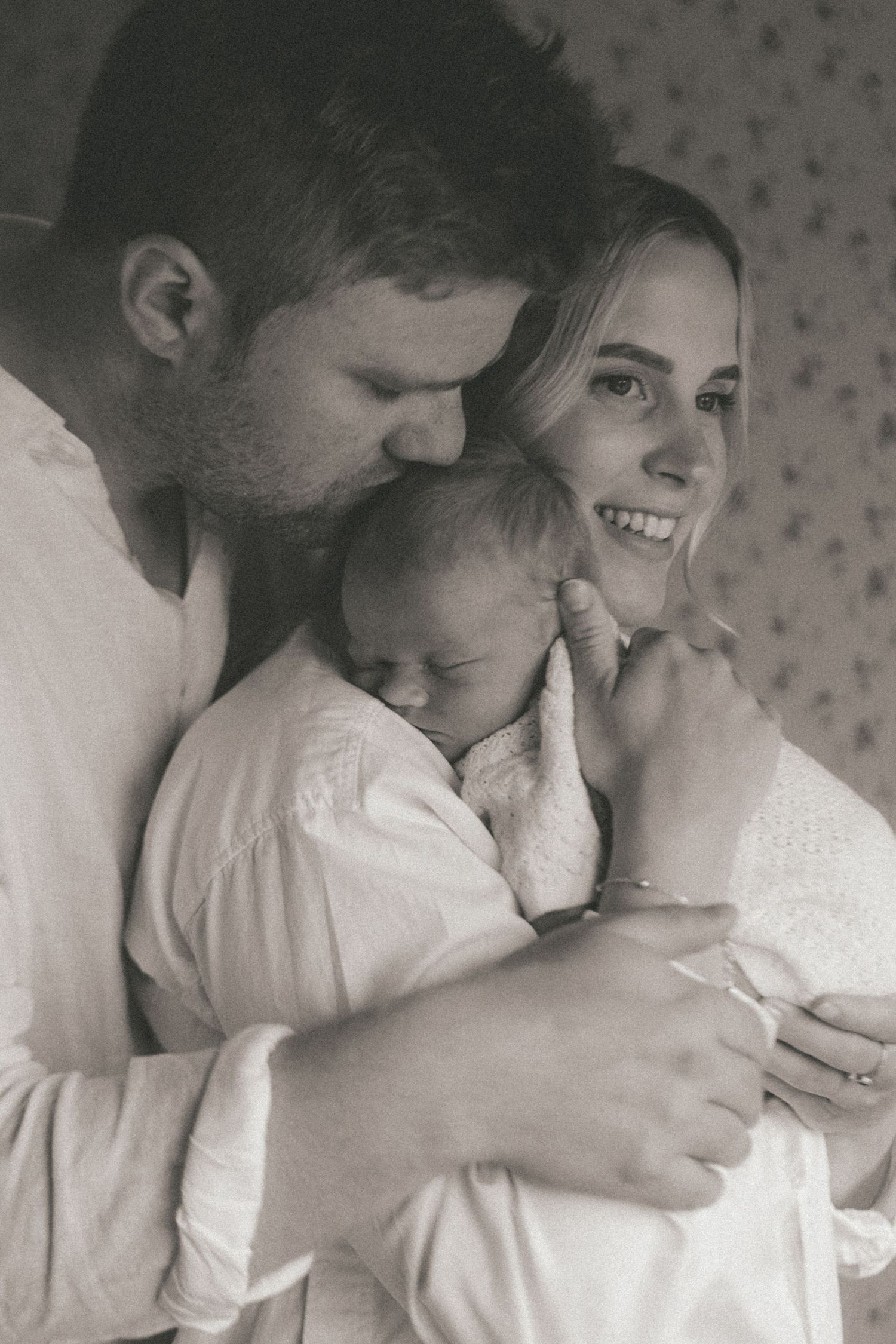 A tender black and white photo sequence showing a couple in white clothing sharing intimate moments together.
